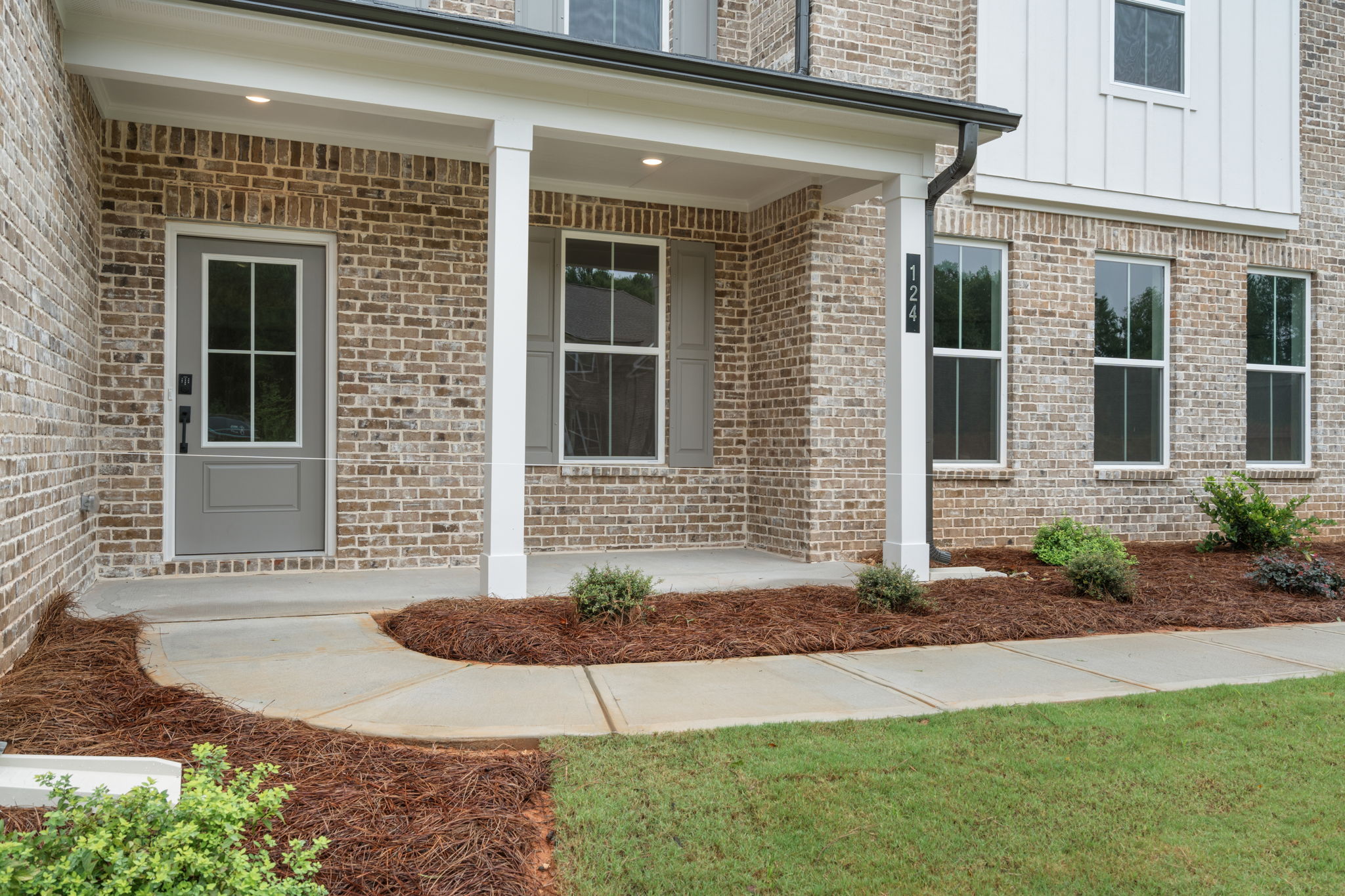 A brick building with a front yard.