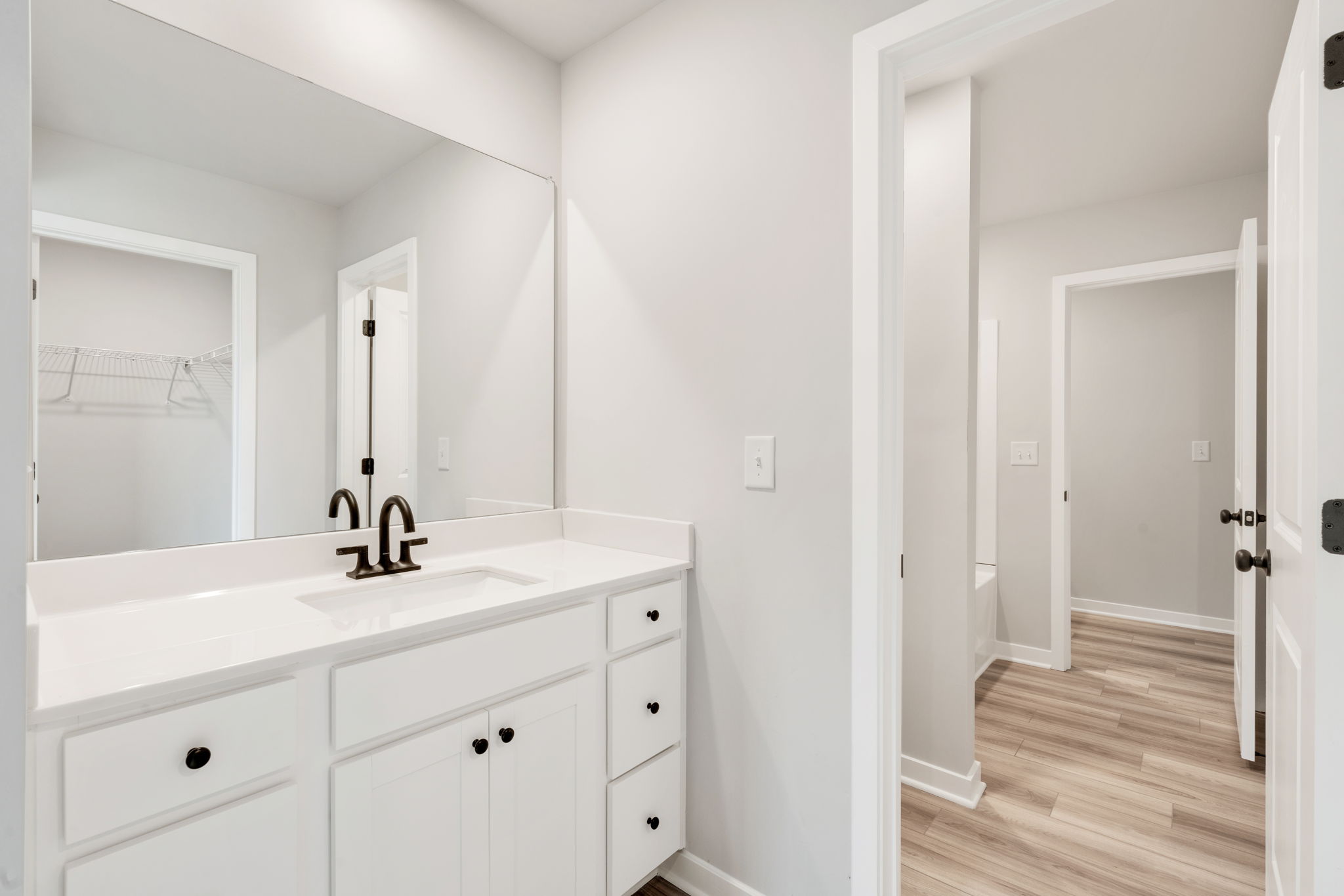 A bathroom with white cabinets.
