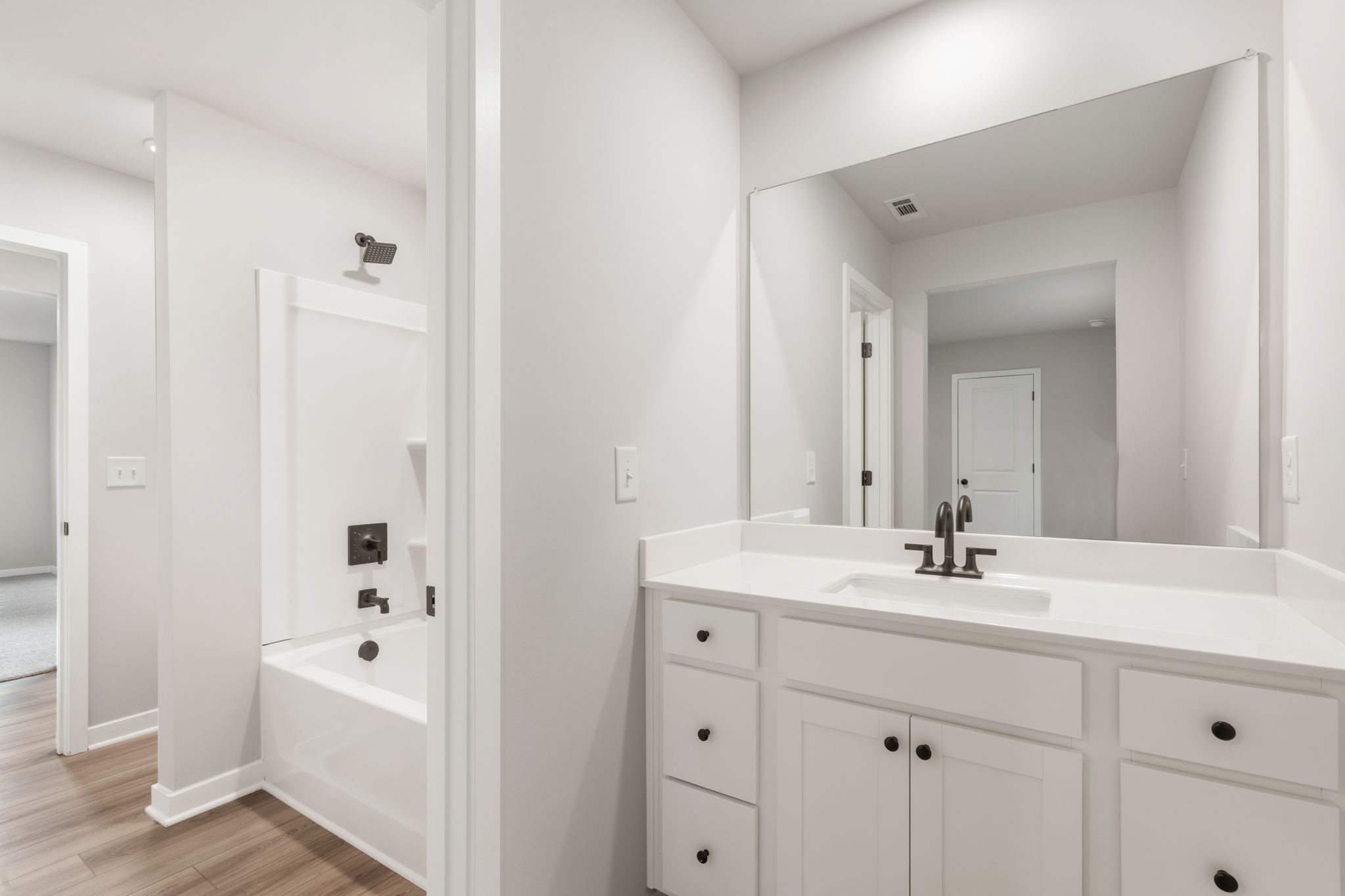 A bathroom with white cabinets.