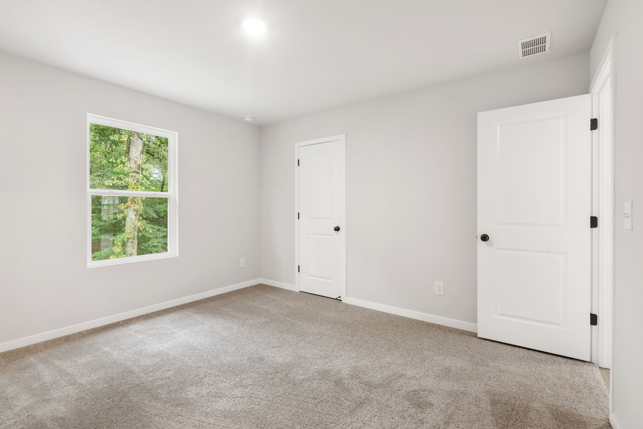 A room with white doors and a window.