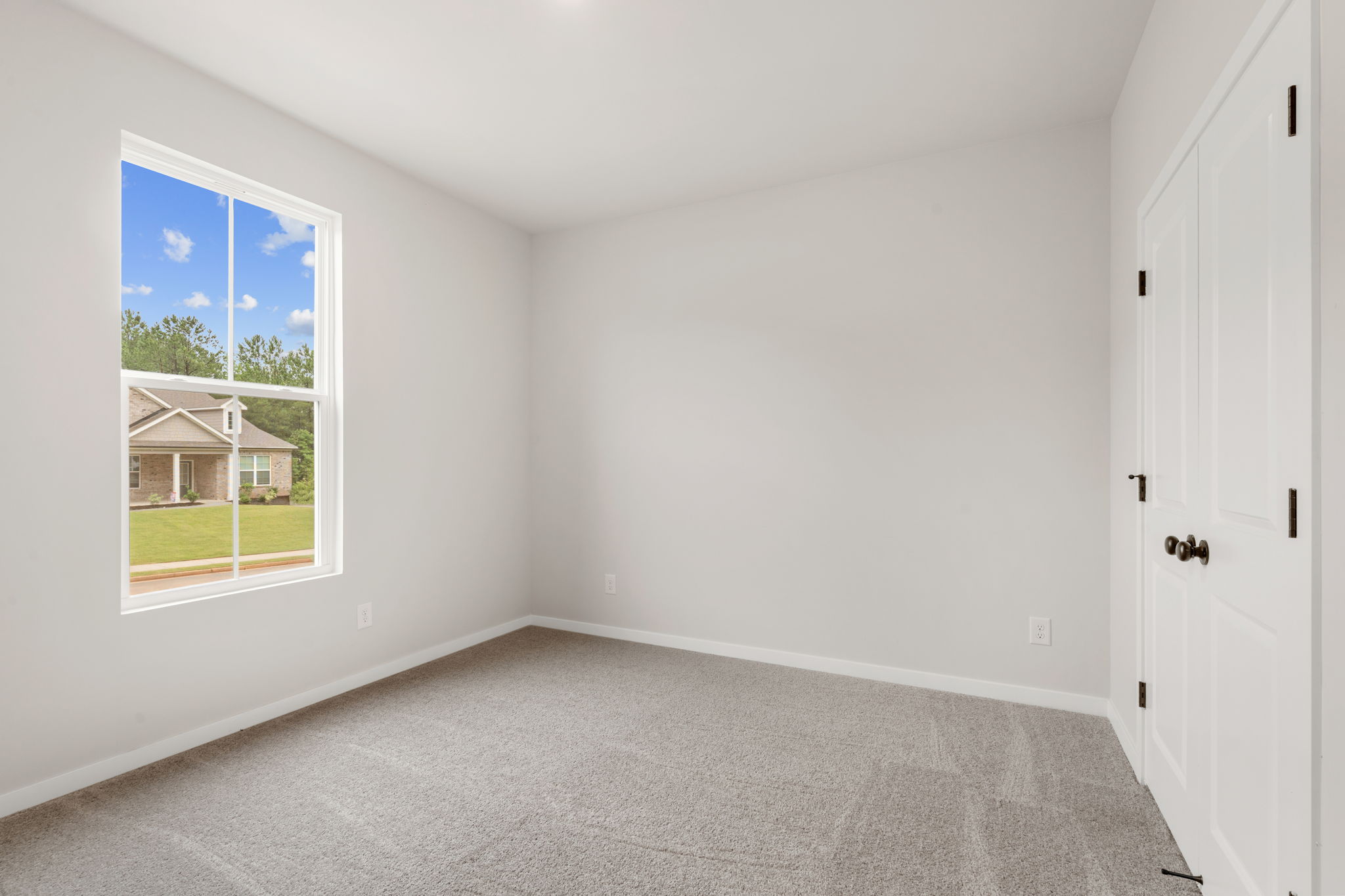 A room with a window and a carpet.