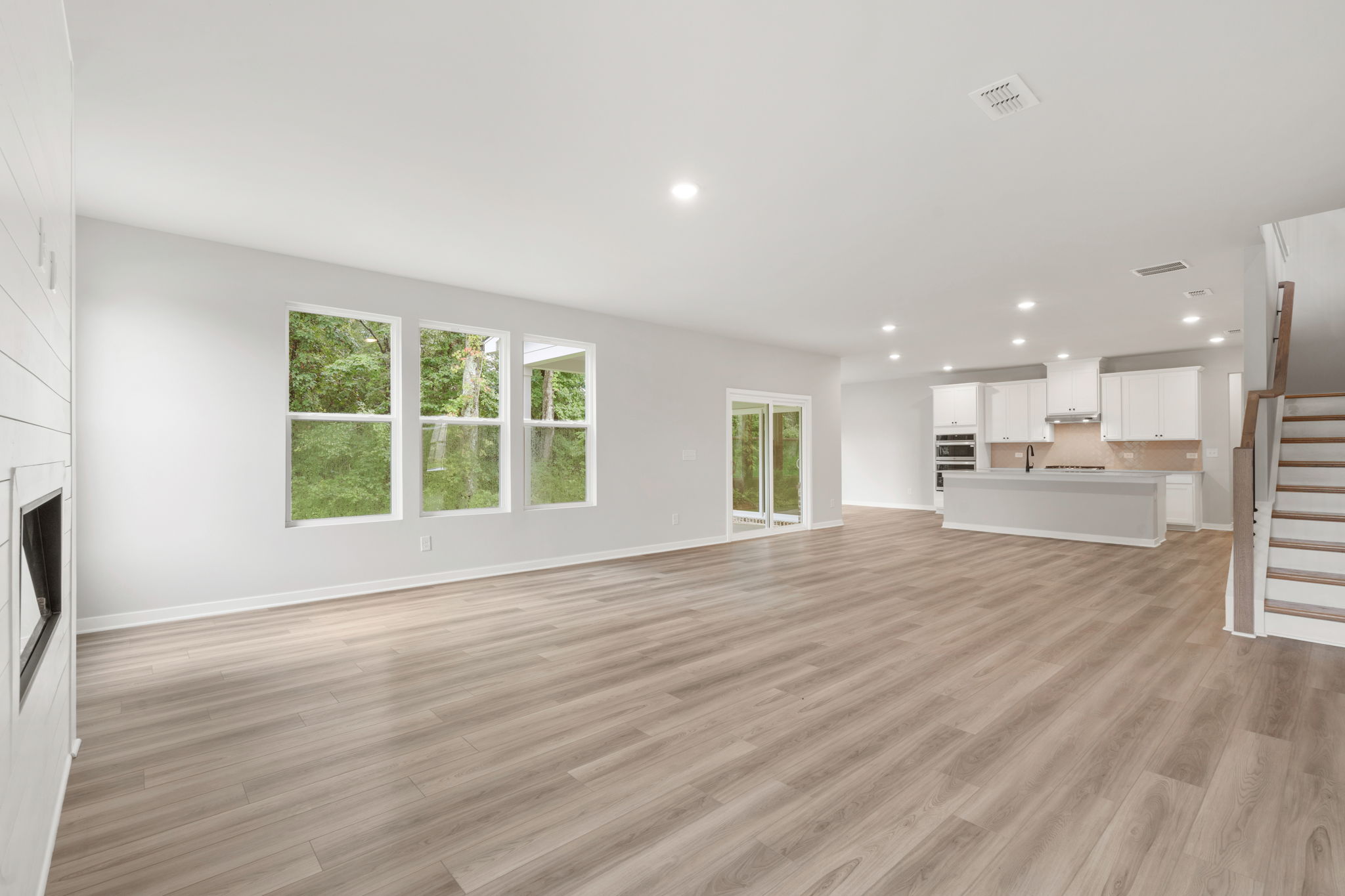 A large empty room with a wood floor and a wood floor.