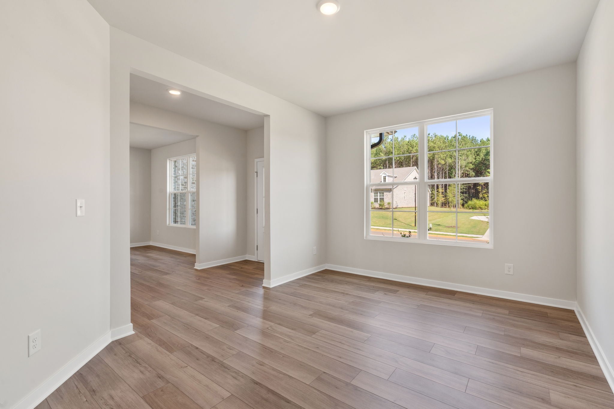 A room with a wood floor and a window.