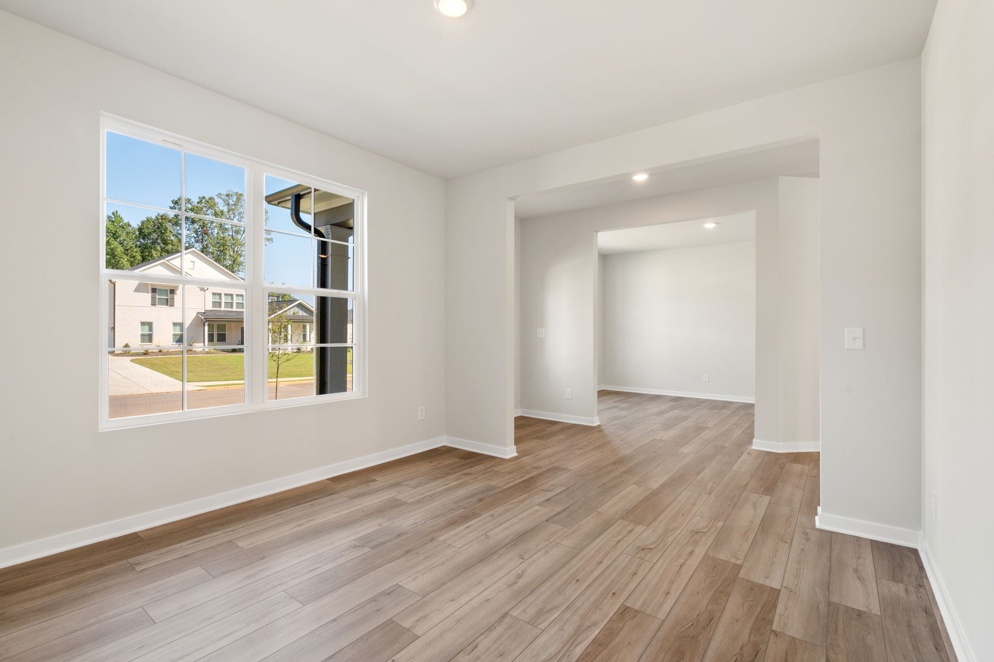 A room with a wood floor and a window with a wood floor.