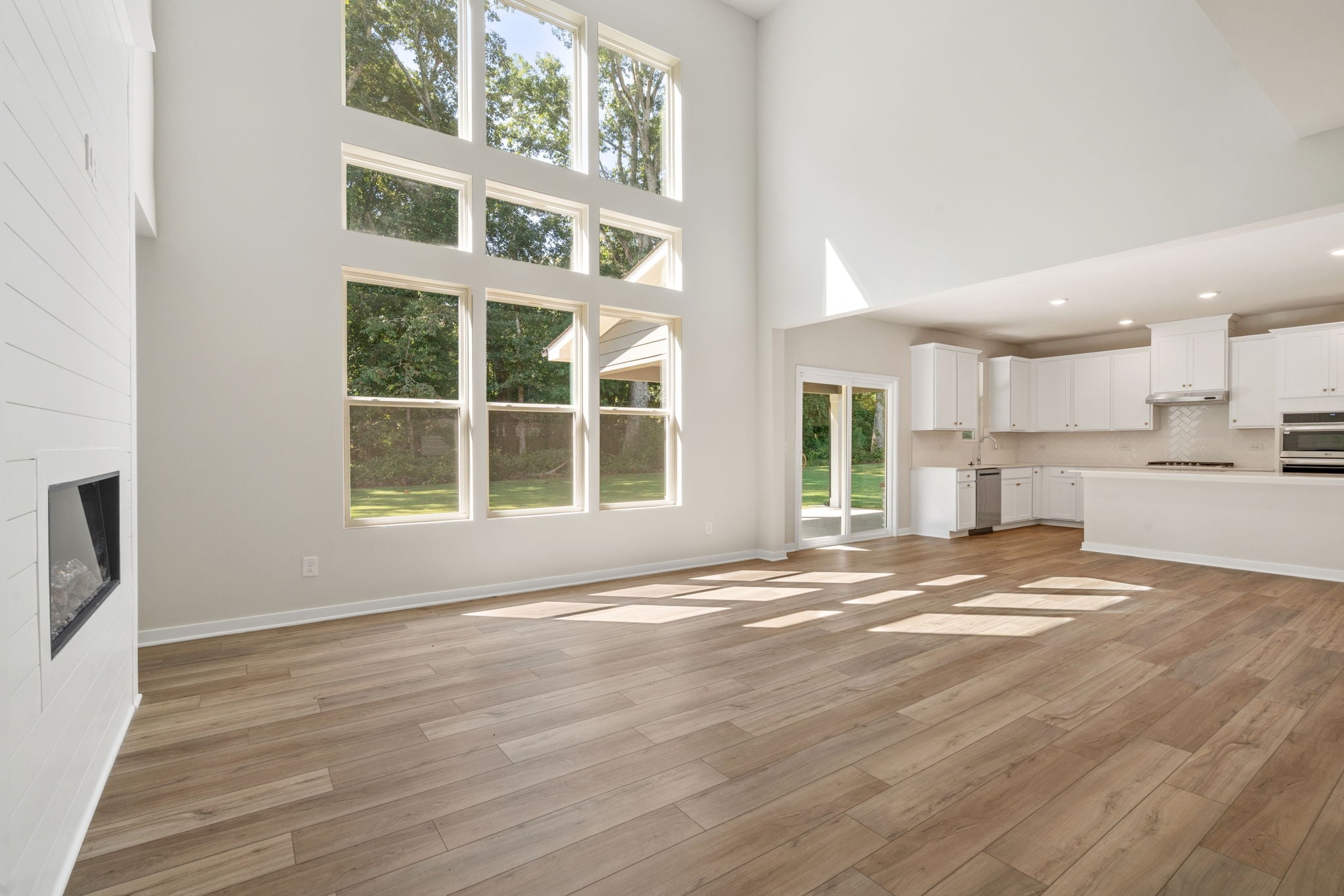 A room with a wood floor and a window with a wood floor.