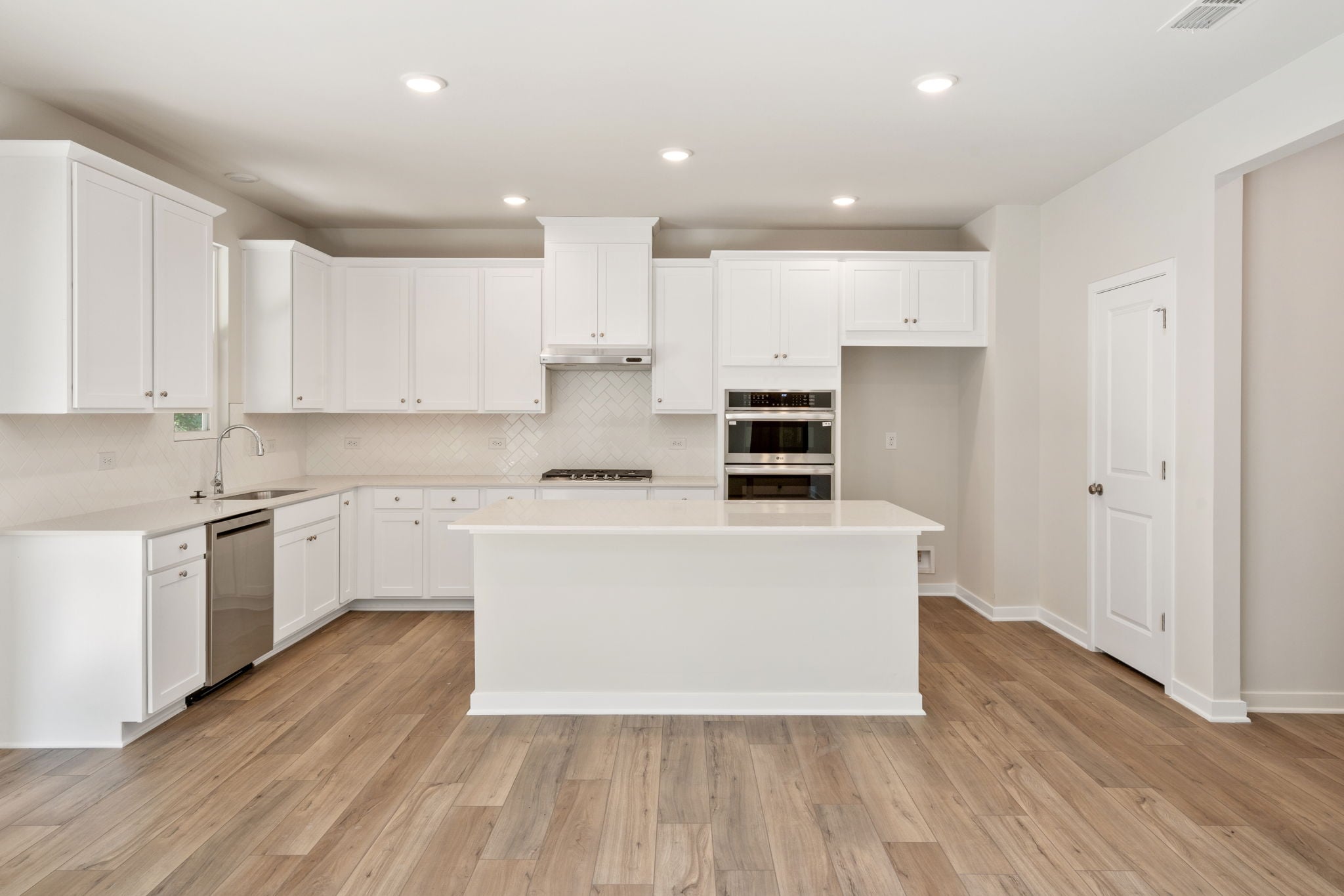 A kitchen with white cabinets.