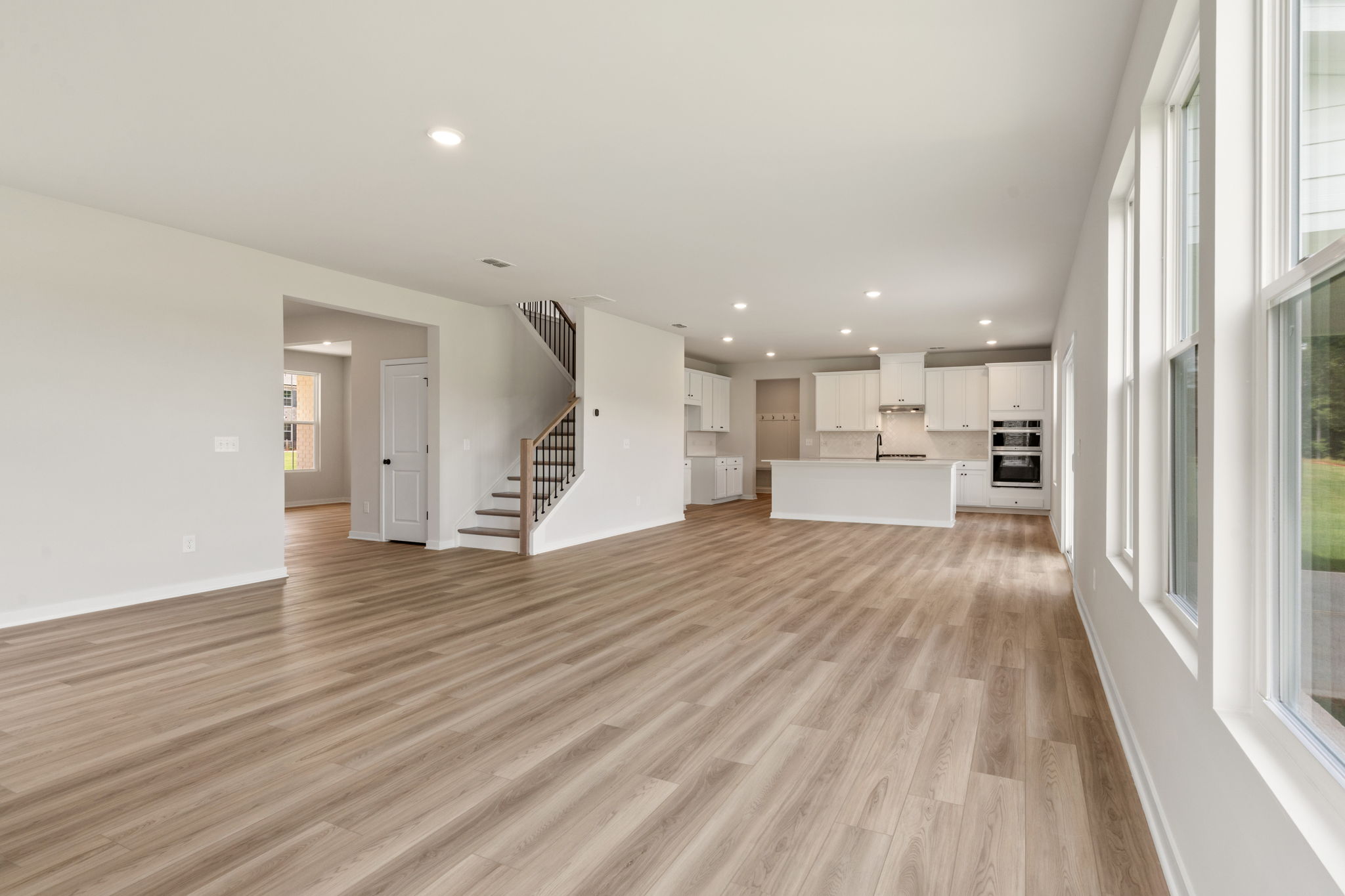 A large empty room with a wood floor and white walls.
