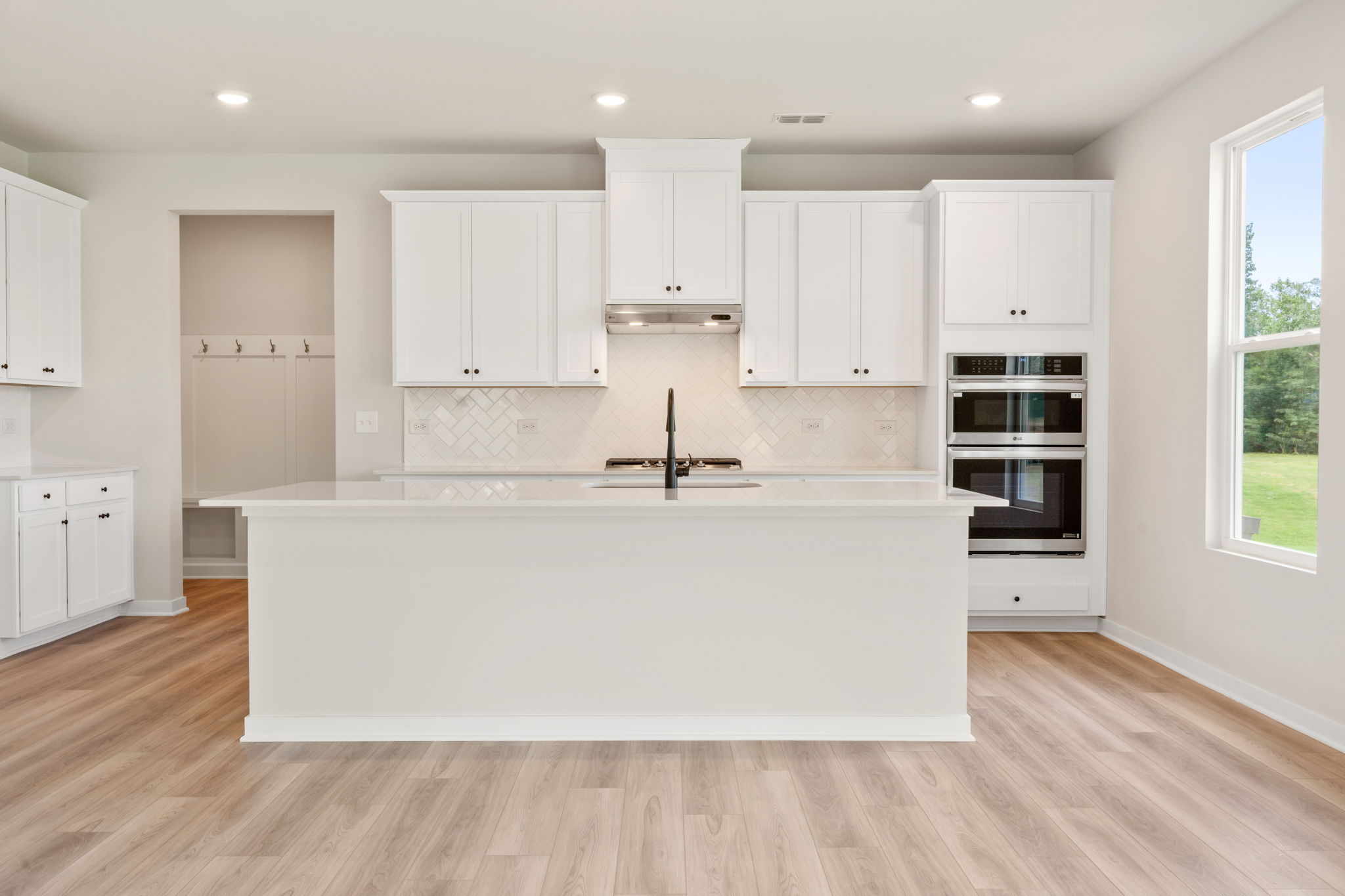 A kitchen with white cabinets.