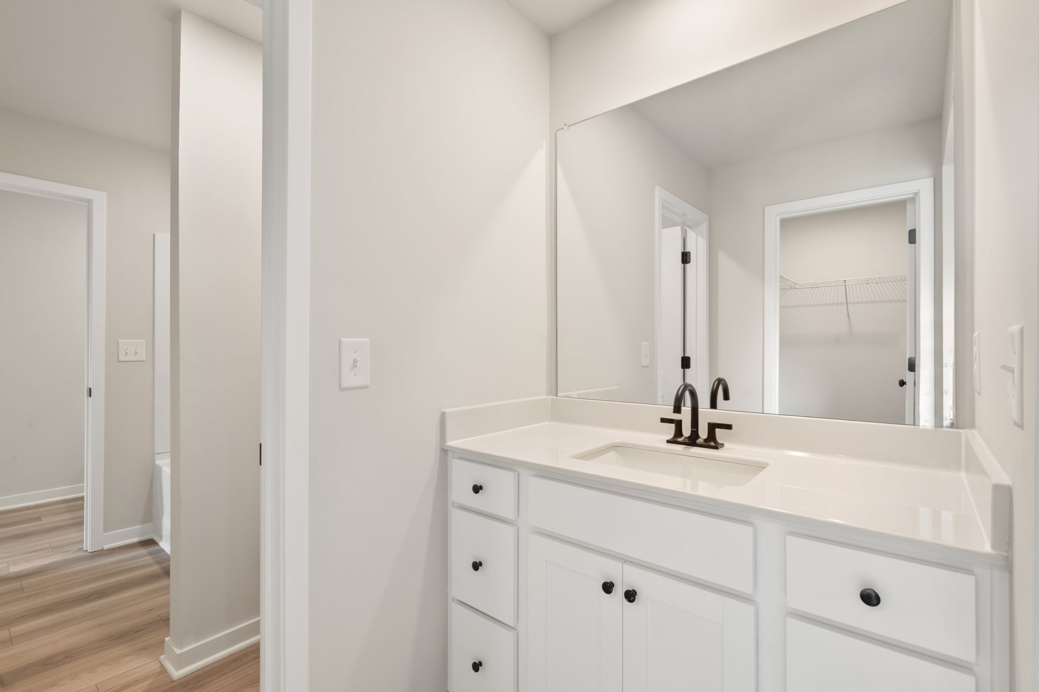 A bathroom with white cabinets.