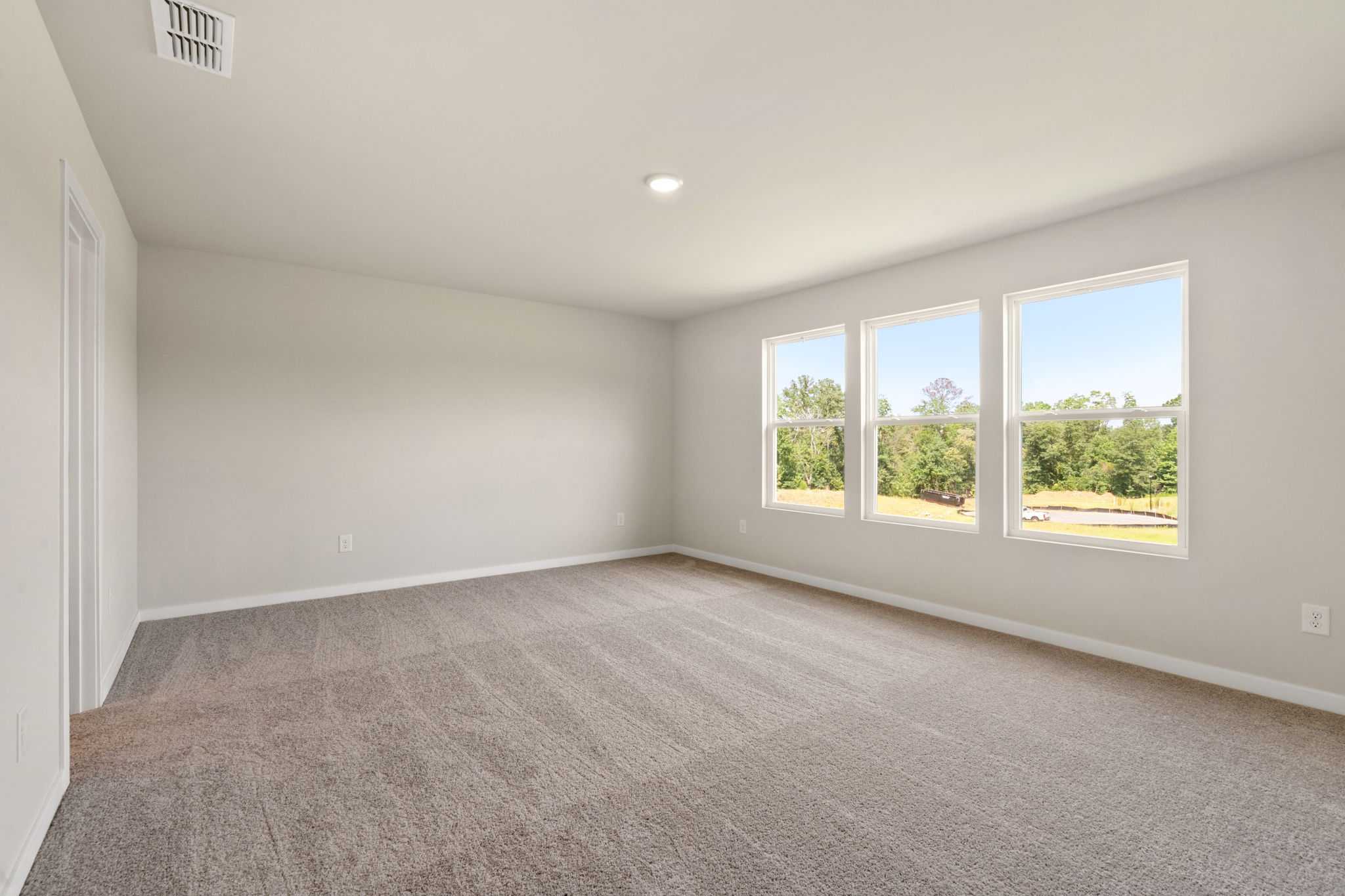 A room with windows and a carpet.