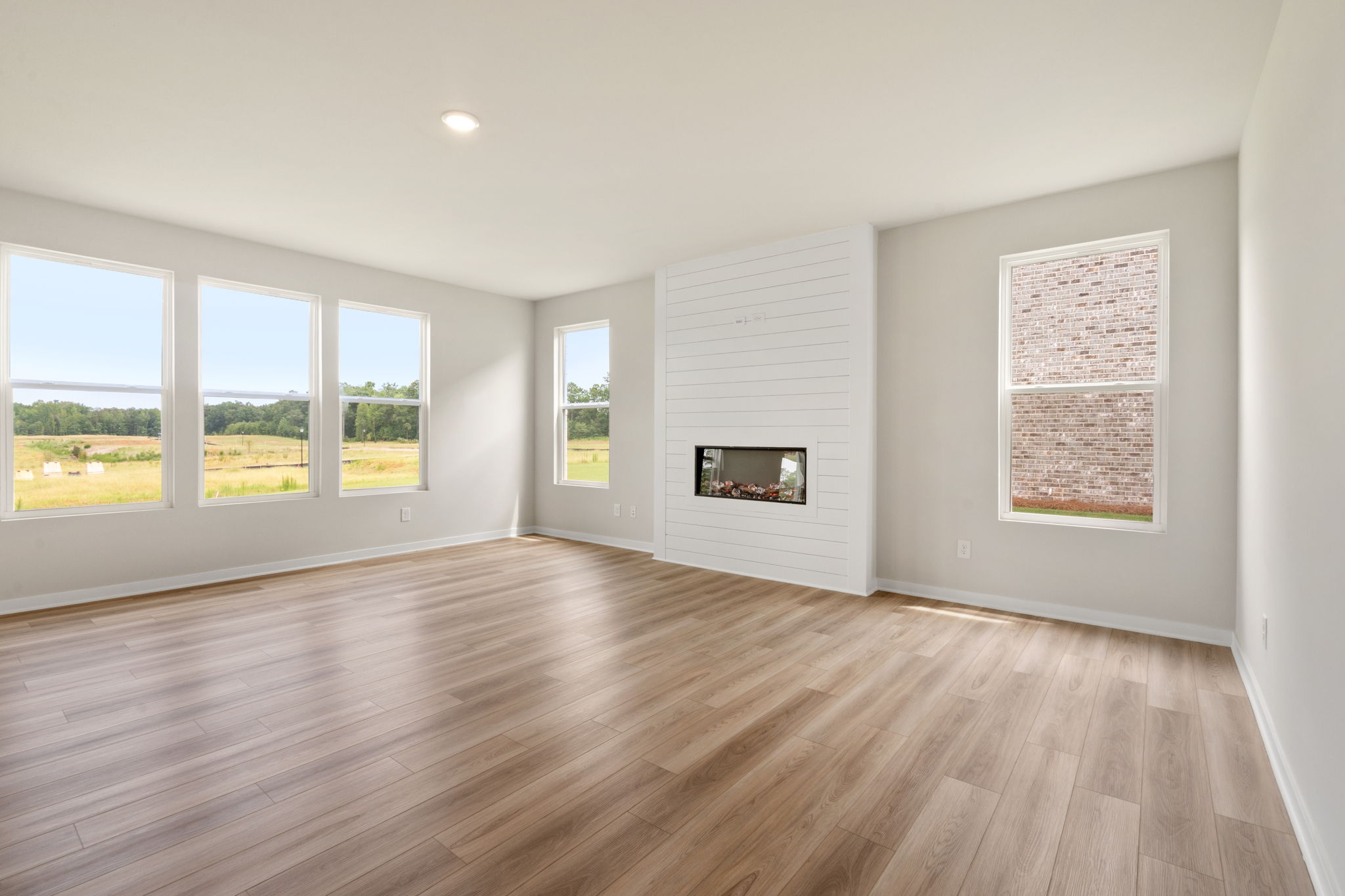 A room with a wood floor and windows.