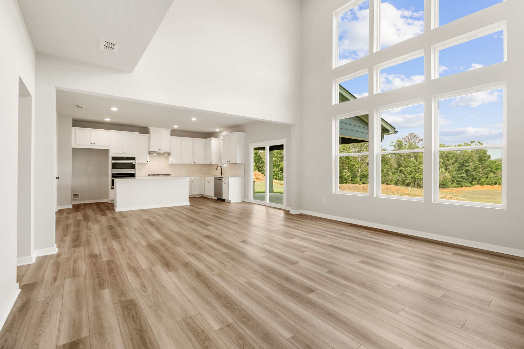 A large empty room with a wood floor and large windows.