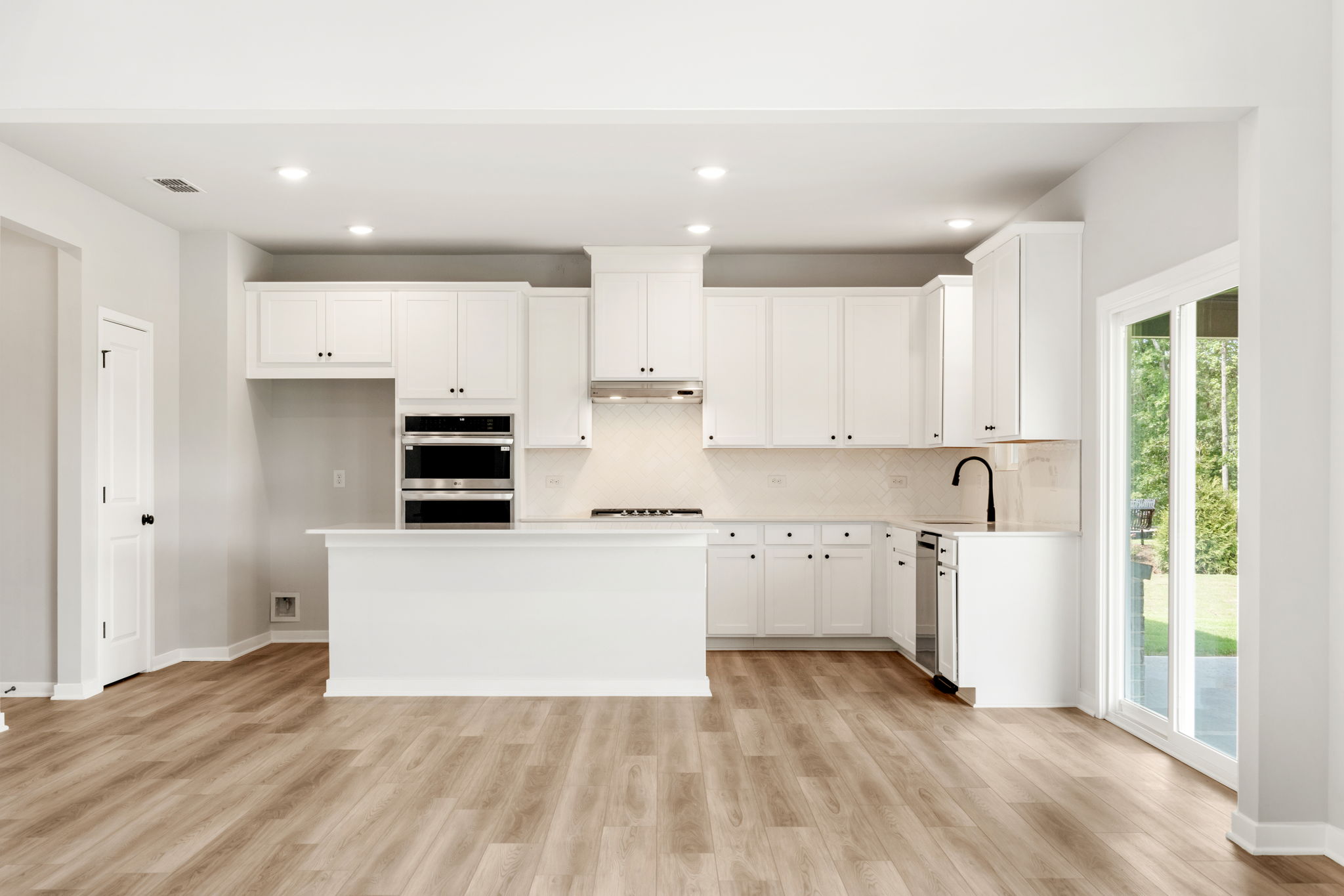 A kitchen with white cabinets.