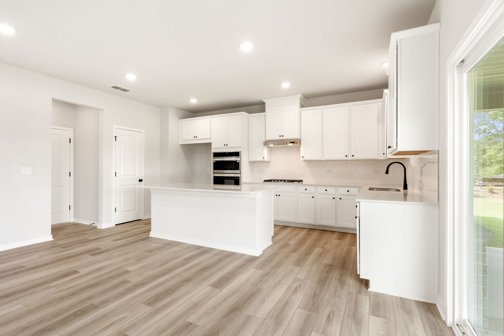 A kitchen with white cabinets.