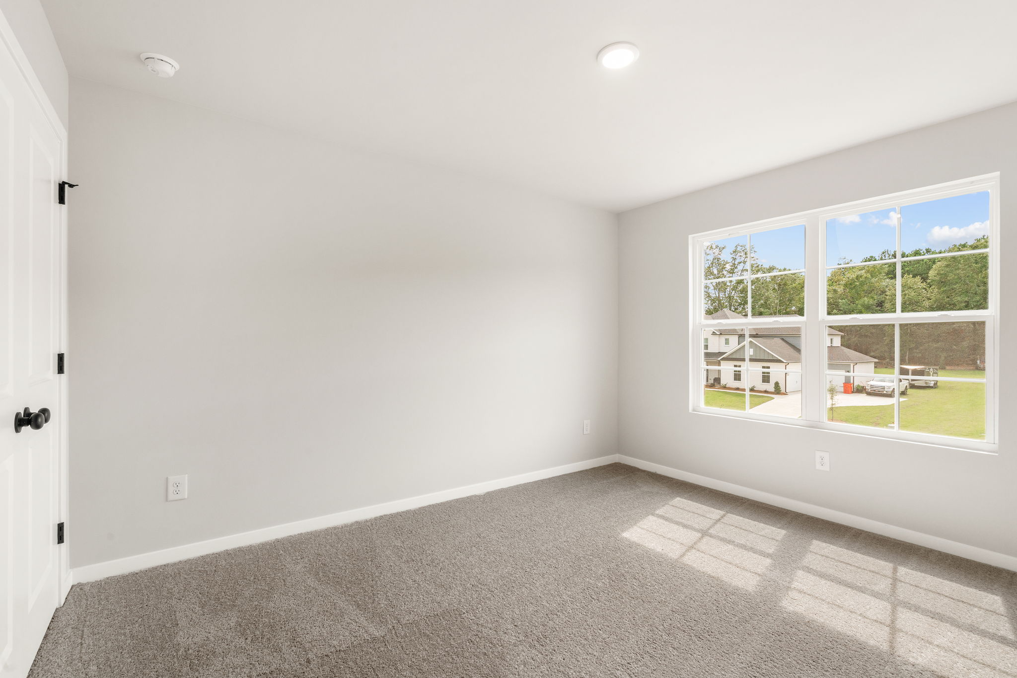 A room with a window and a carpet.