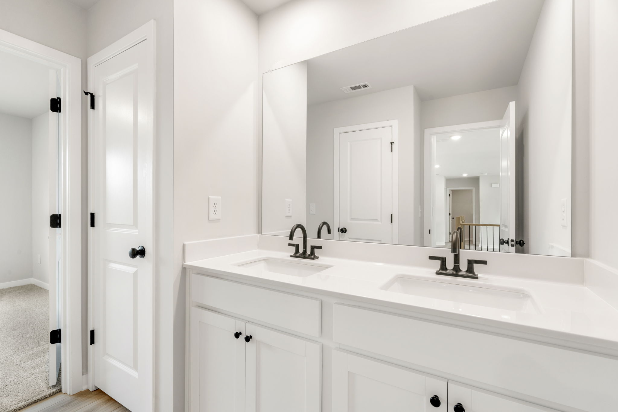 A bathroom with white cabinets.