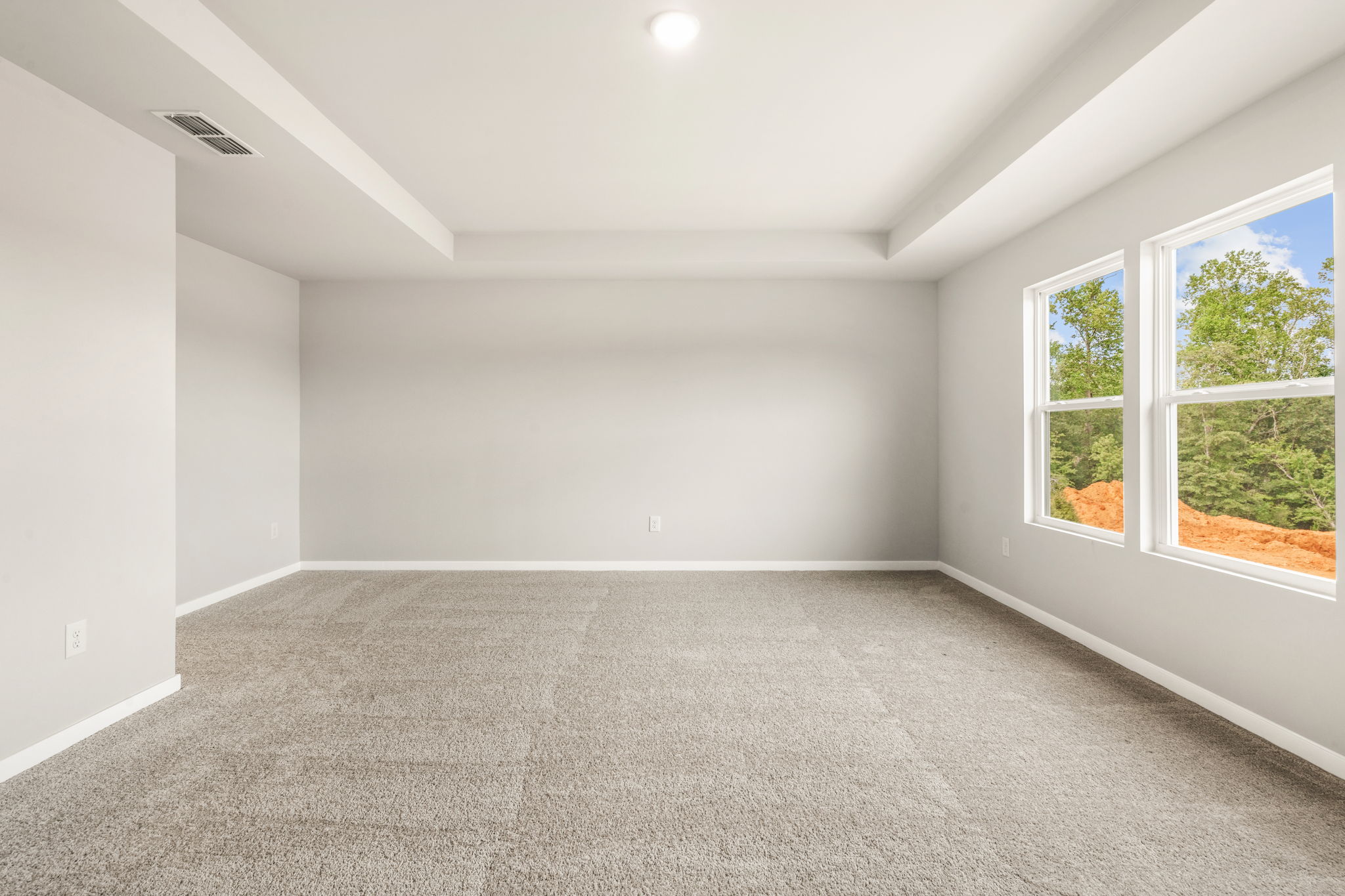 A room with a carpet and windows.