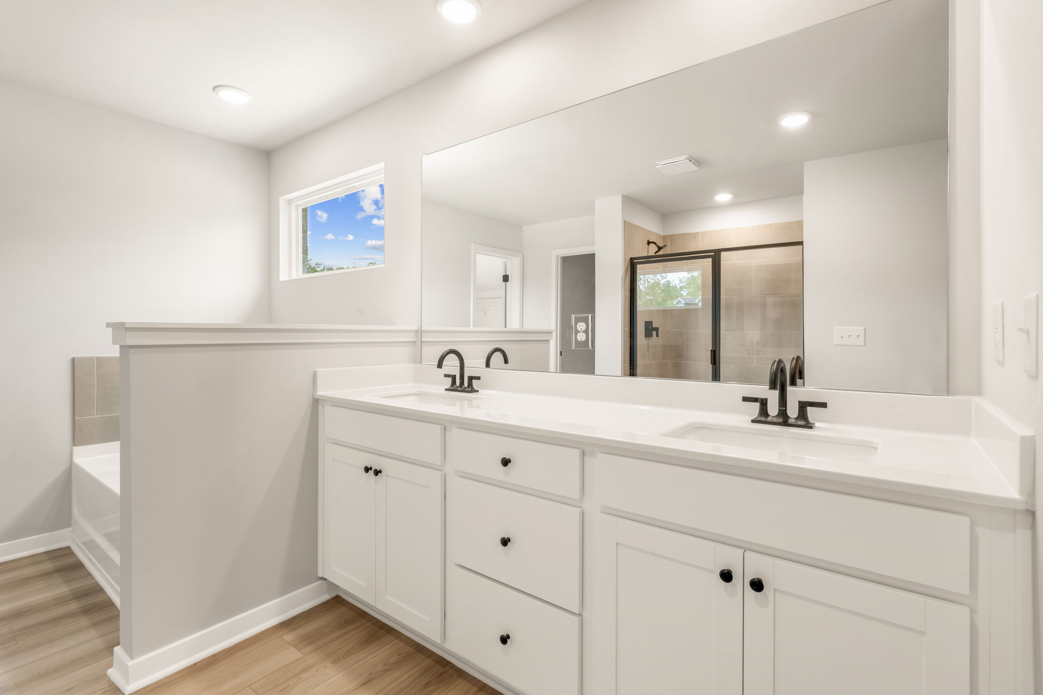 A bathroom with white cabinets.