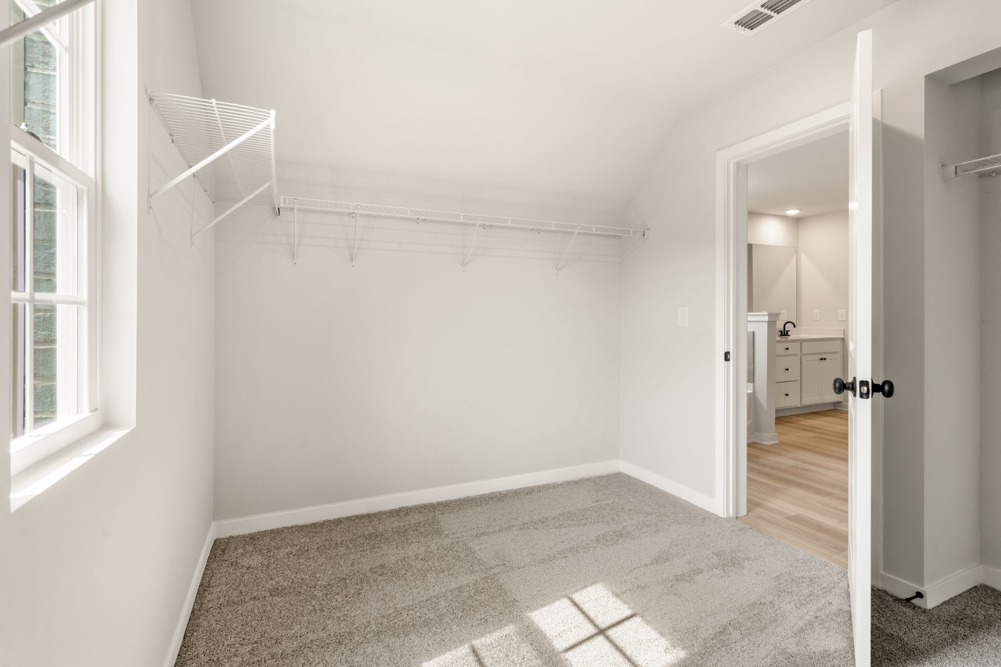 A hallway with a door and a window.