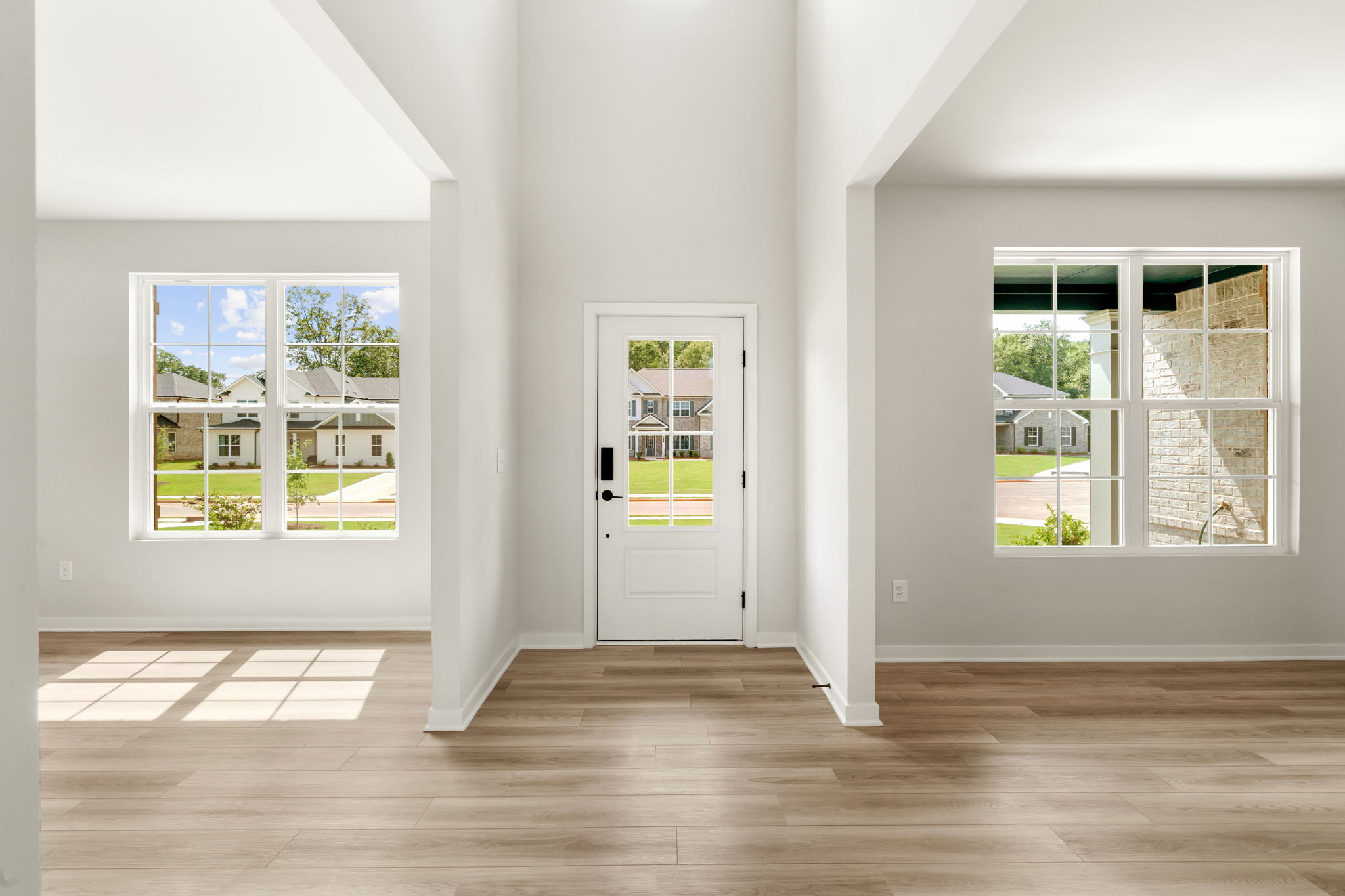 A room with windows and a wood floor.