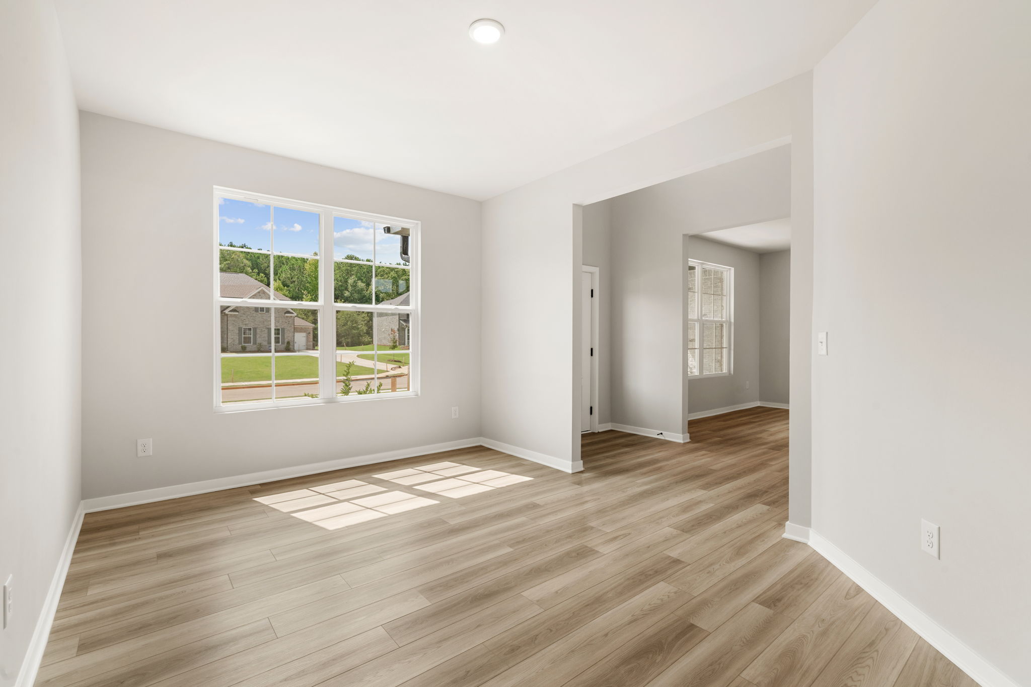 A room with a wood floor and a window.