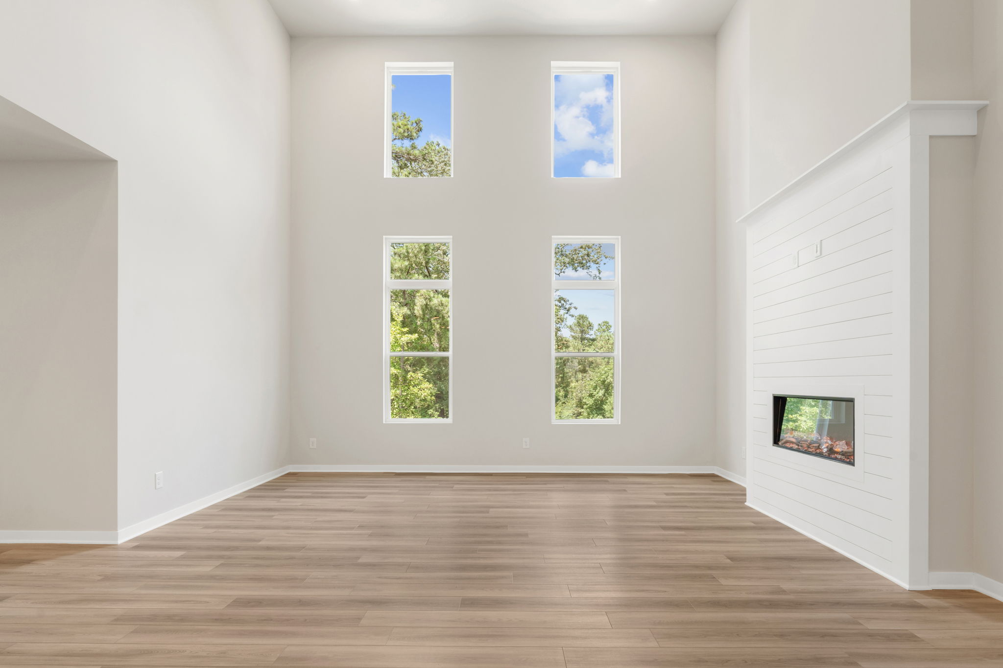 A room with a wood floor and white walls with pictures on the wall.