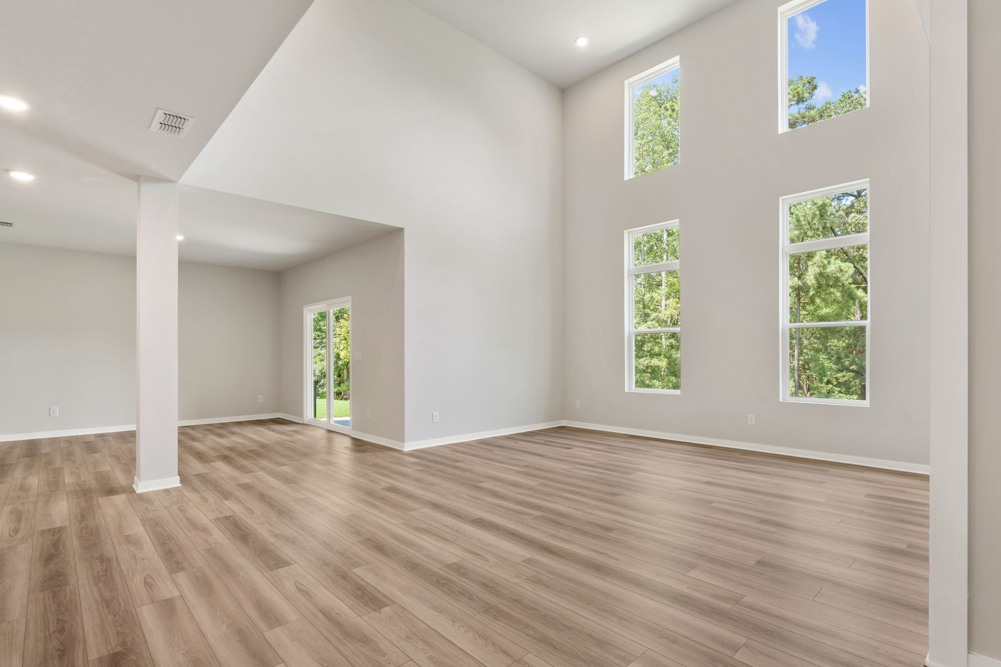 A room with a wood floor and windows.