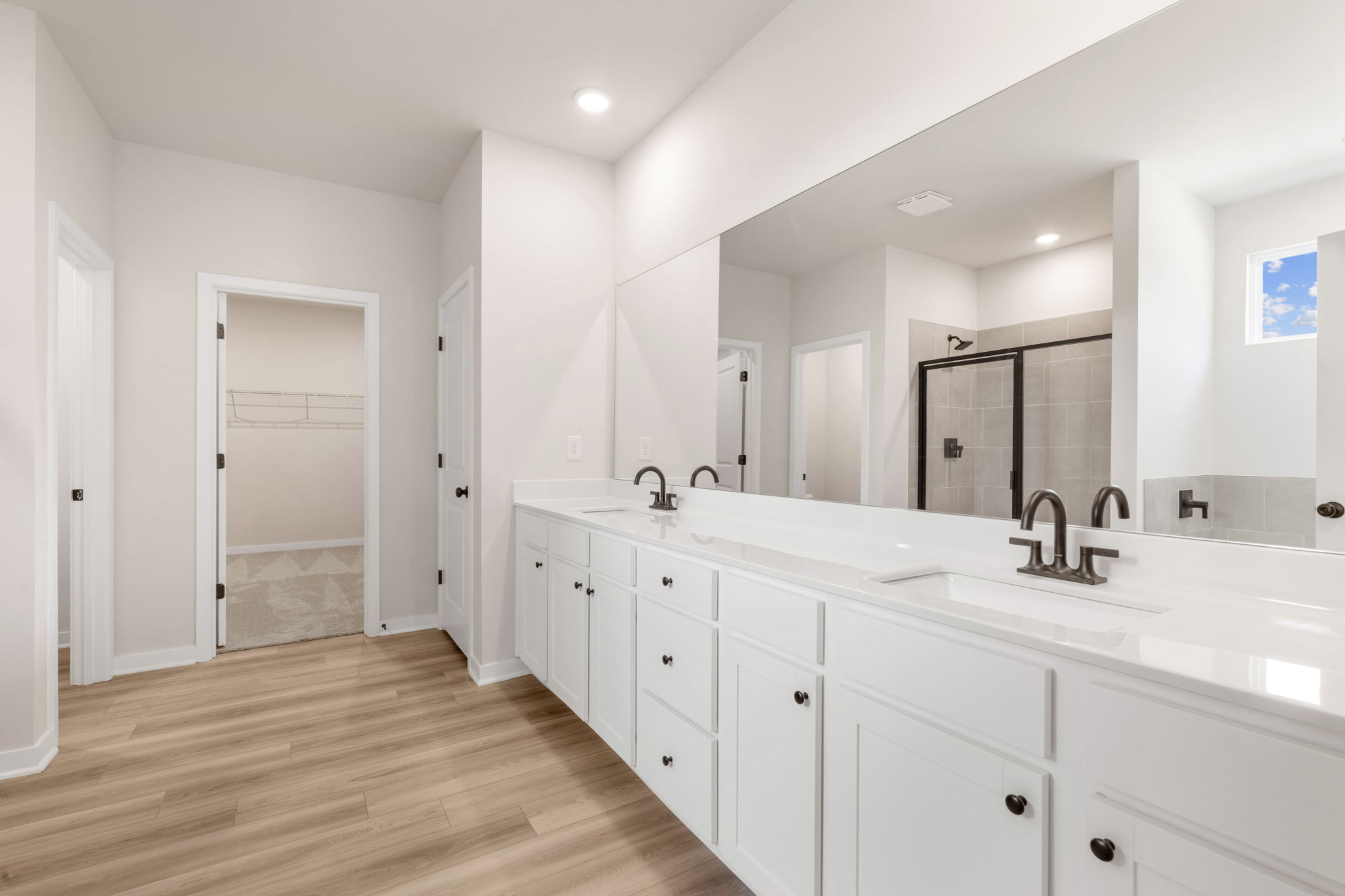 A bathroom with white cabinets.