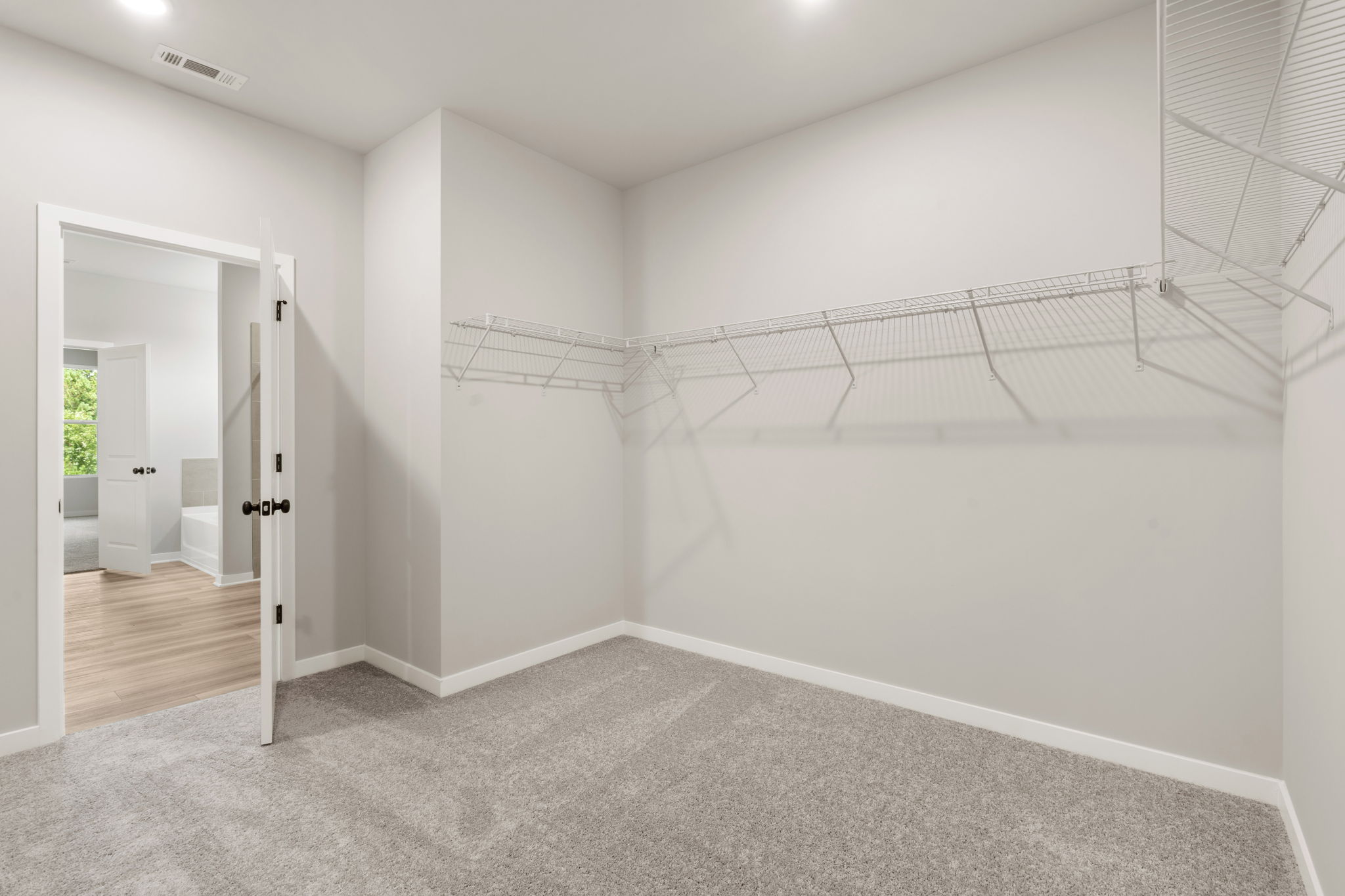 A white hallway with a metal railing.