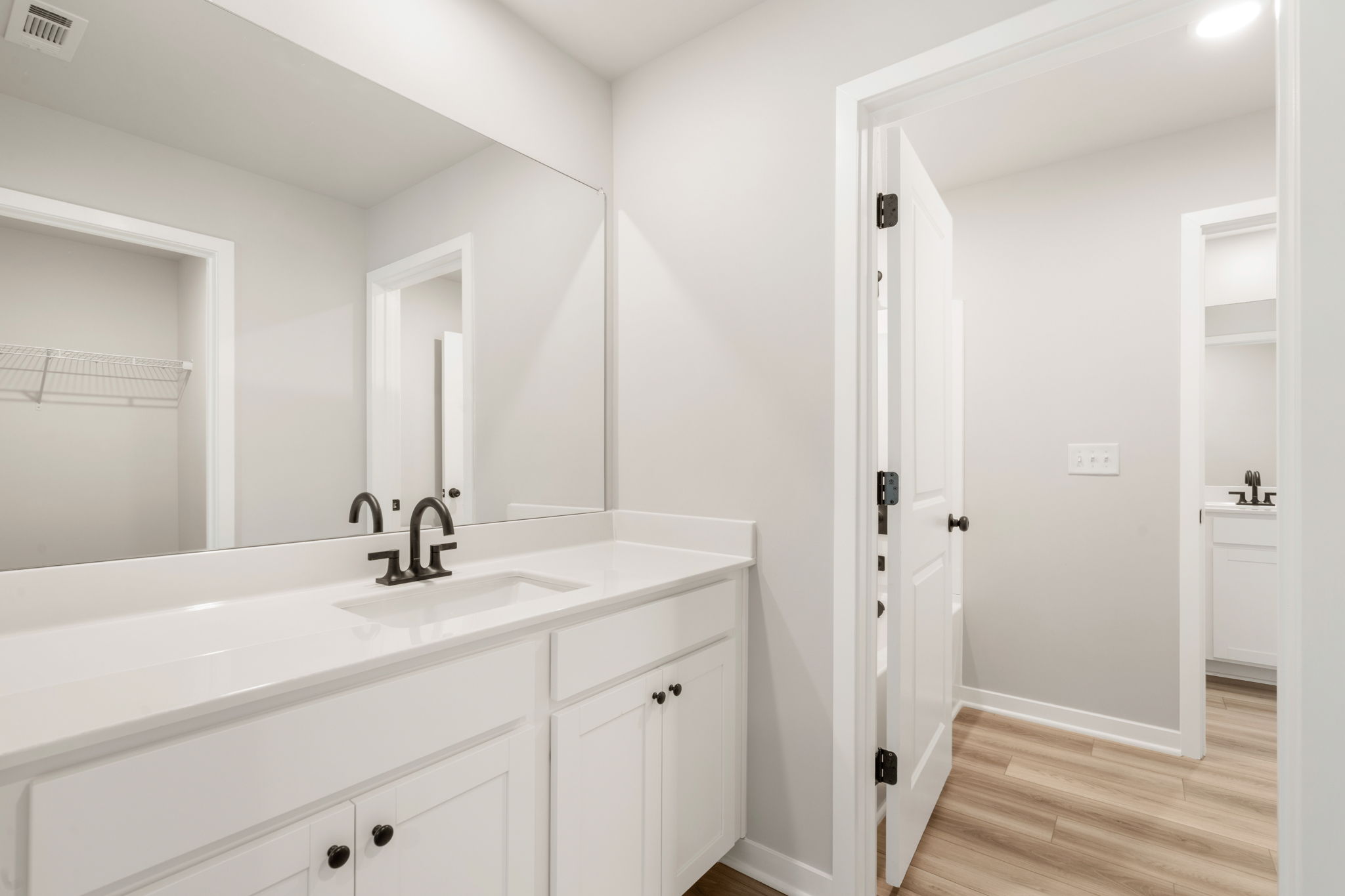 A bathroom with white cabinets.