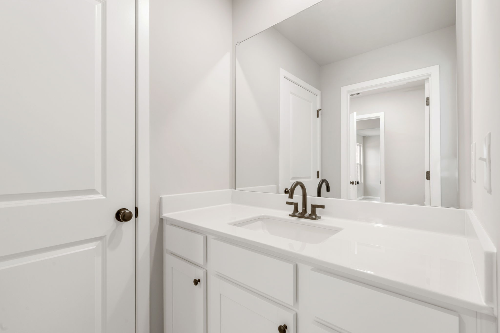 A bathroom with white cabinets.