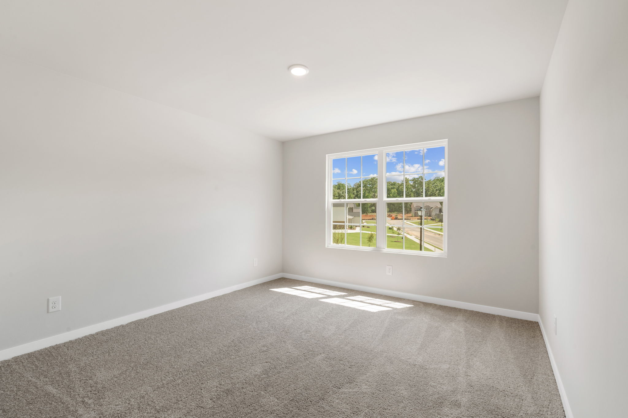 A room with a window and a carpet.