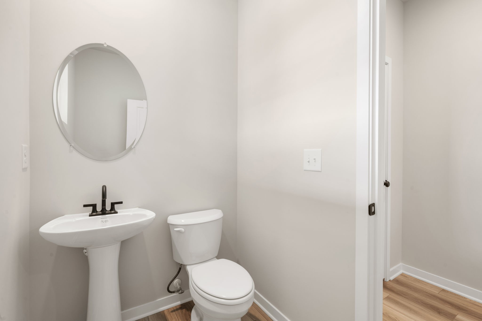 A bathroom with a round mirror.