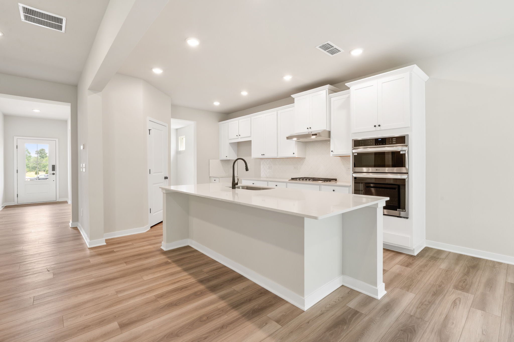 A kitchen with white cabinets.