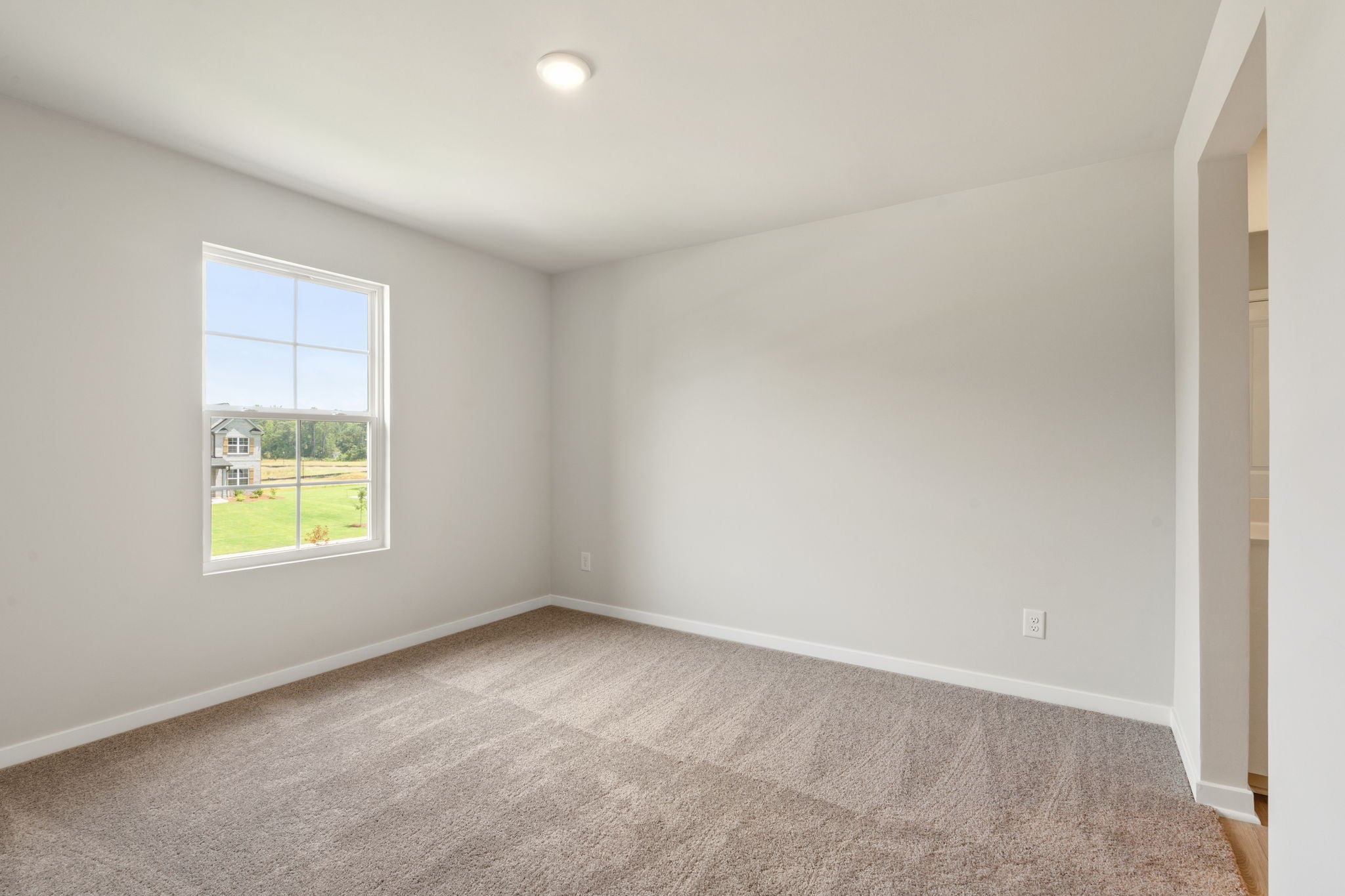 A room with a window and a carpet.