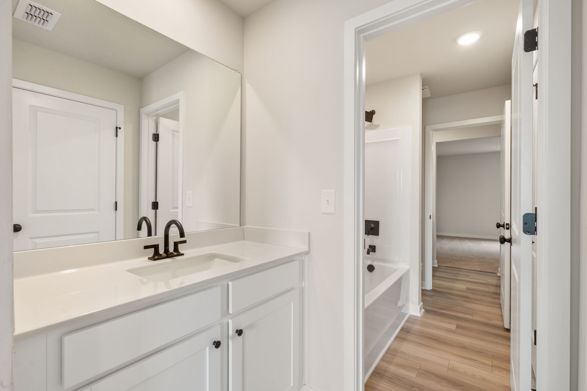 A bathroom with white cabinets.