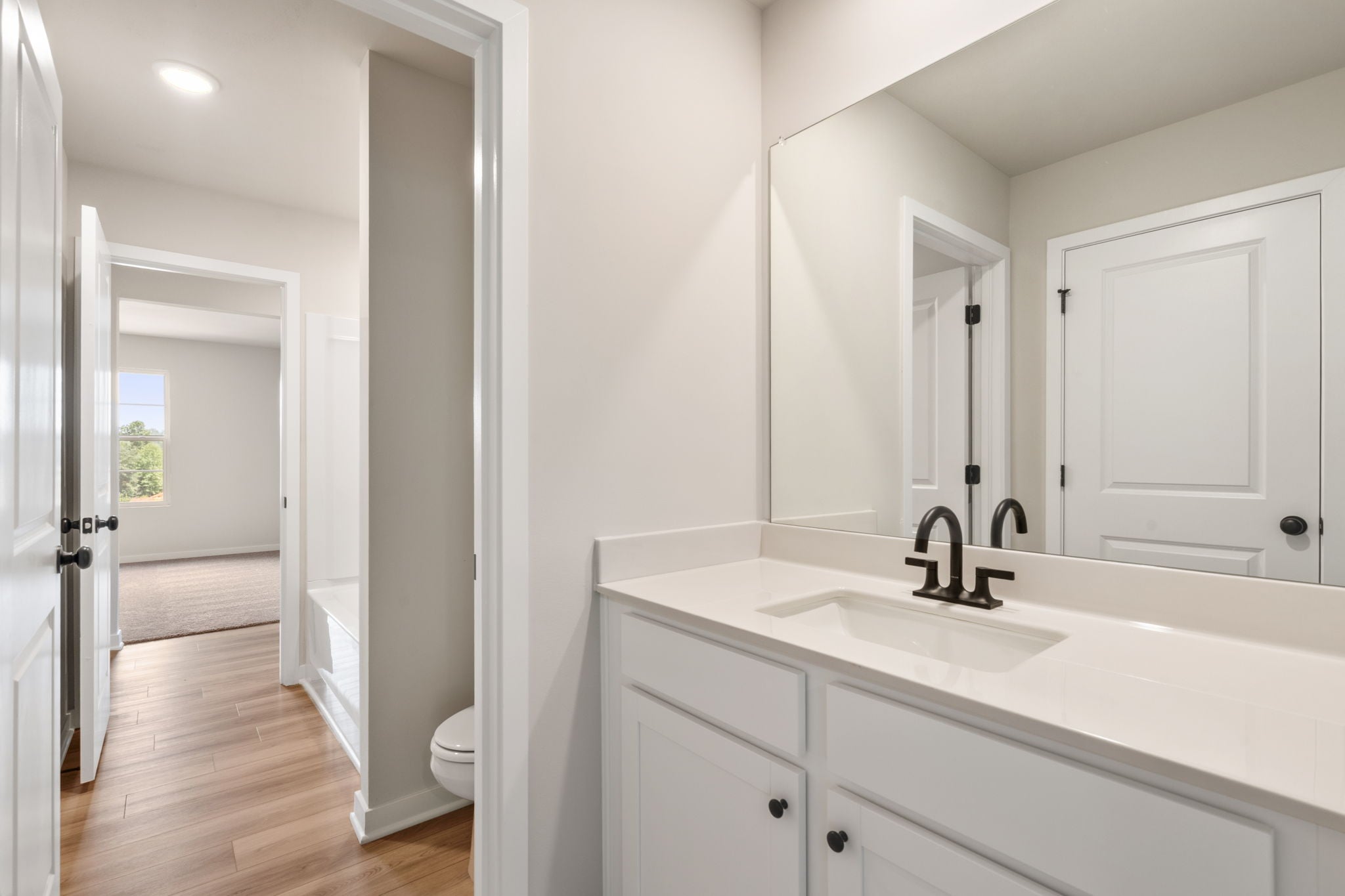 A bathroom with white cabinets.