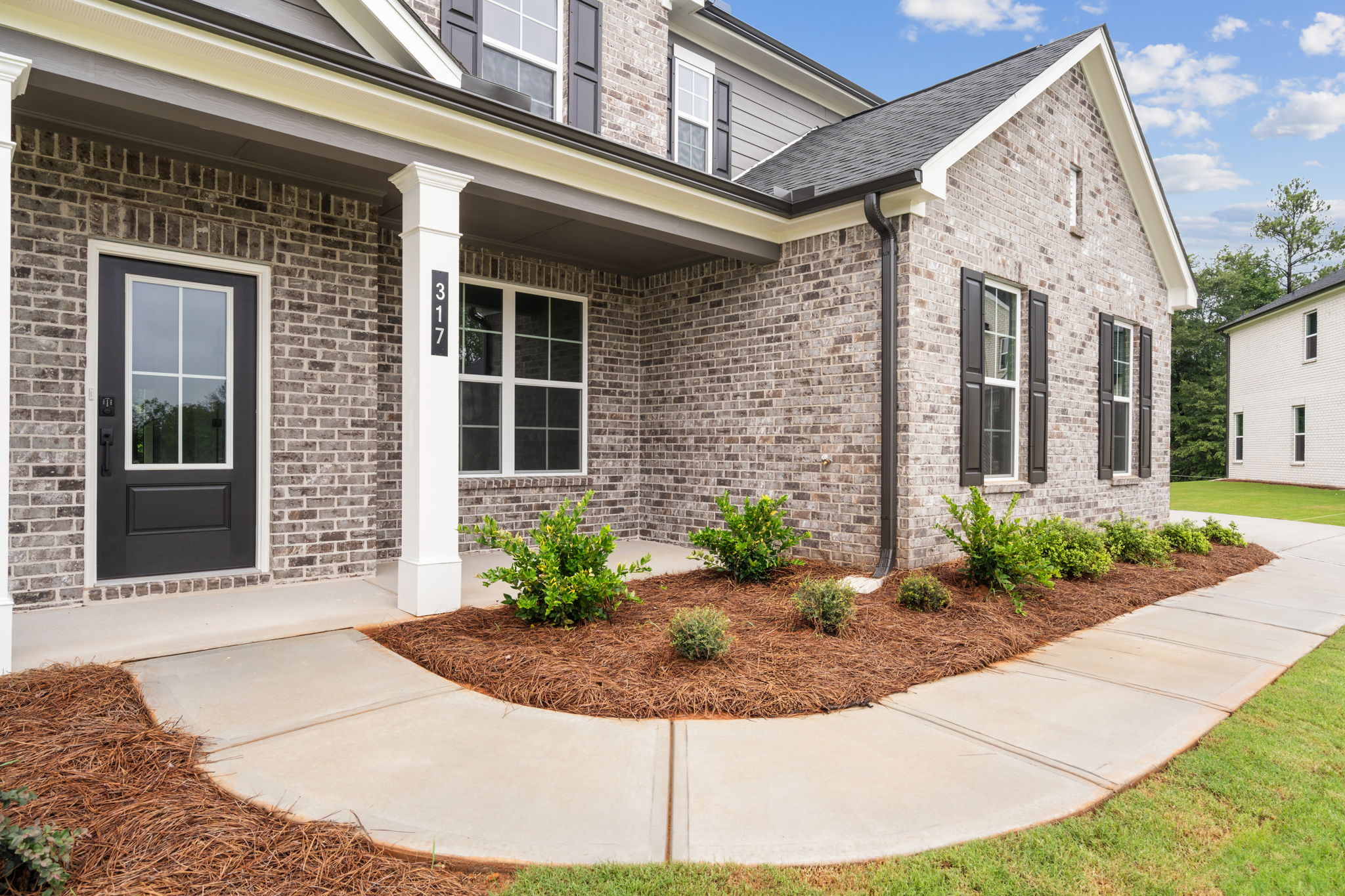 A brick house with a front yard.