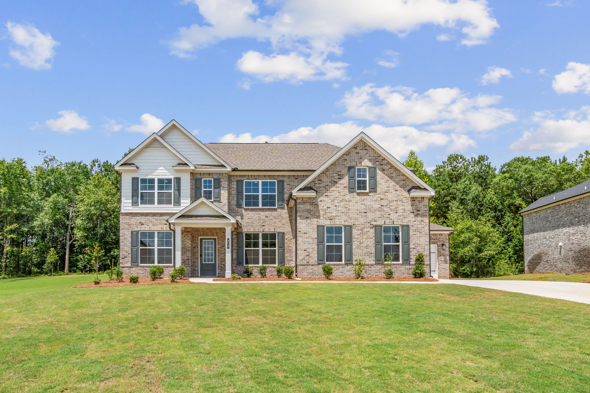 A brick house with a lawn in front of it.