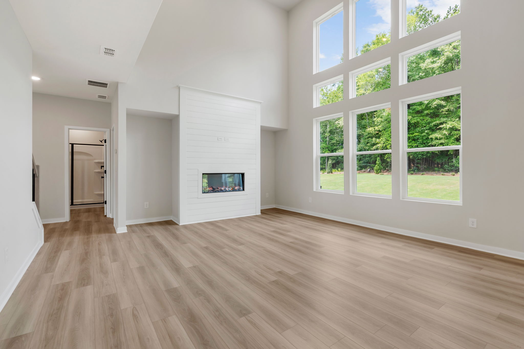 A room with a wood floor and a wood floor with a window.