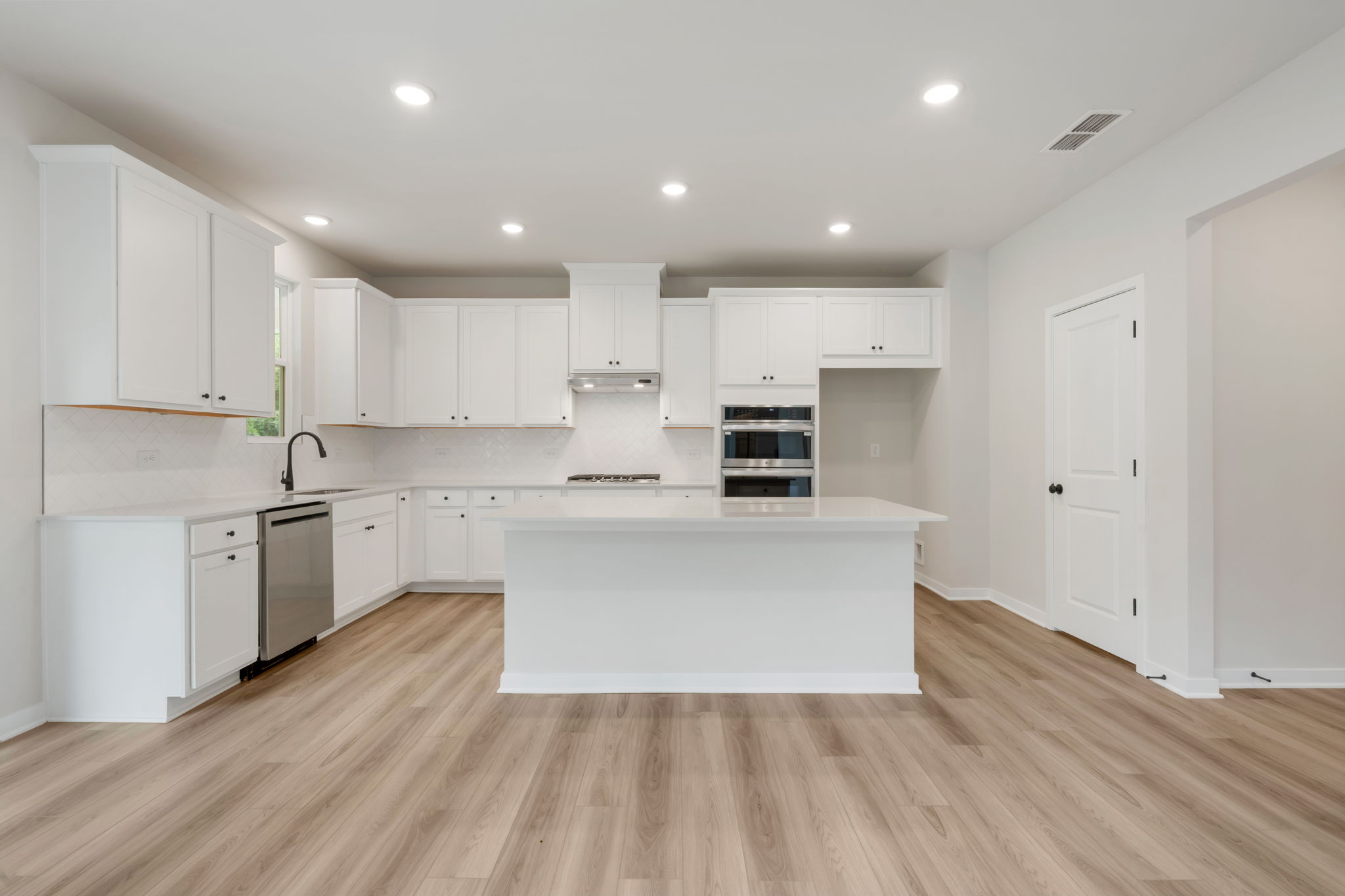 A kitchen with white cabinets.