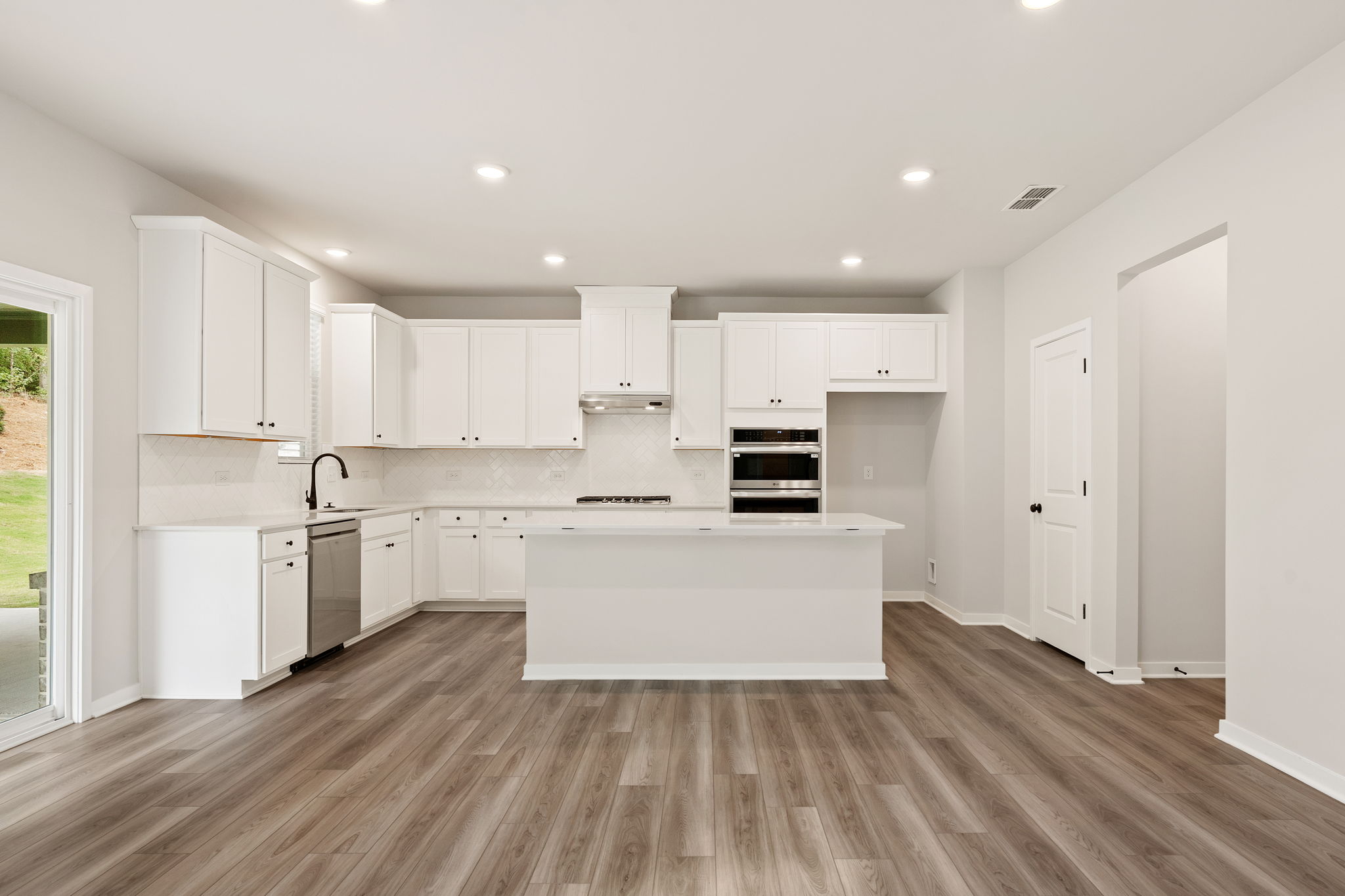 A kitchen with white cabinets.