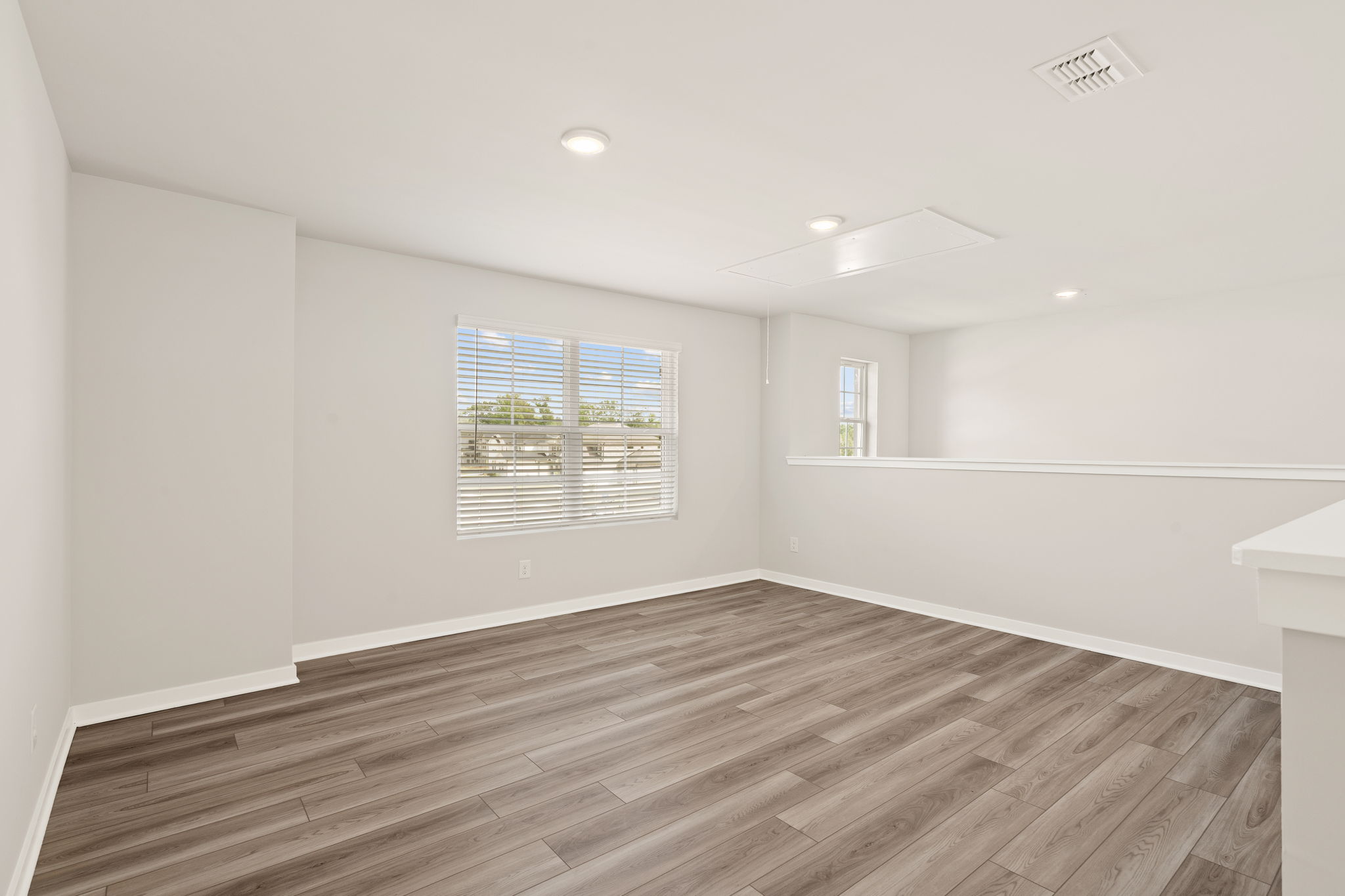 A room with a wood floor and a window.