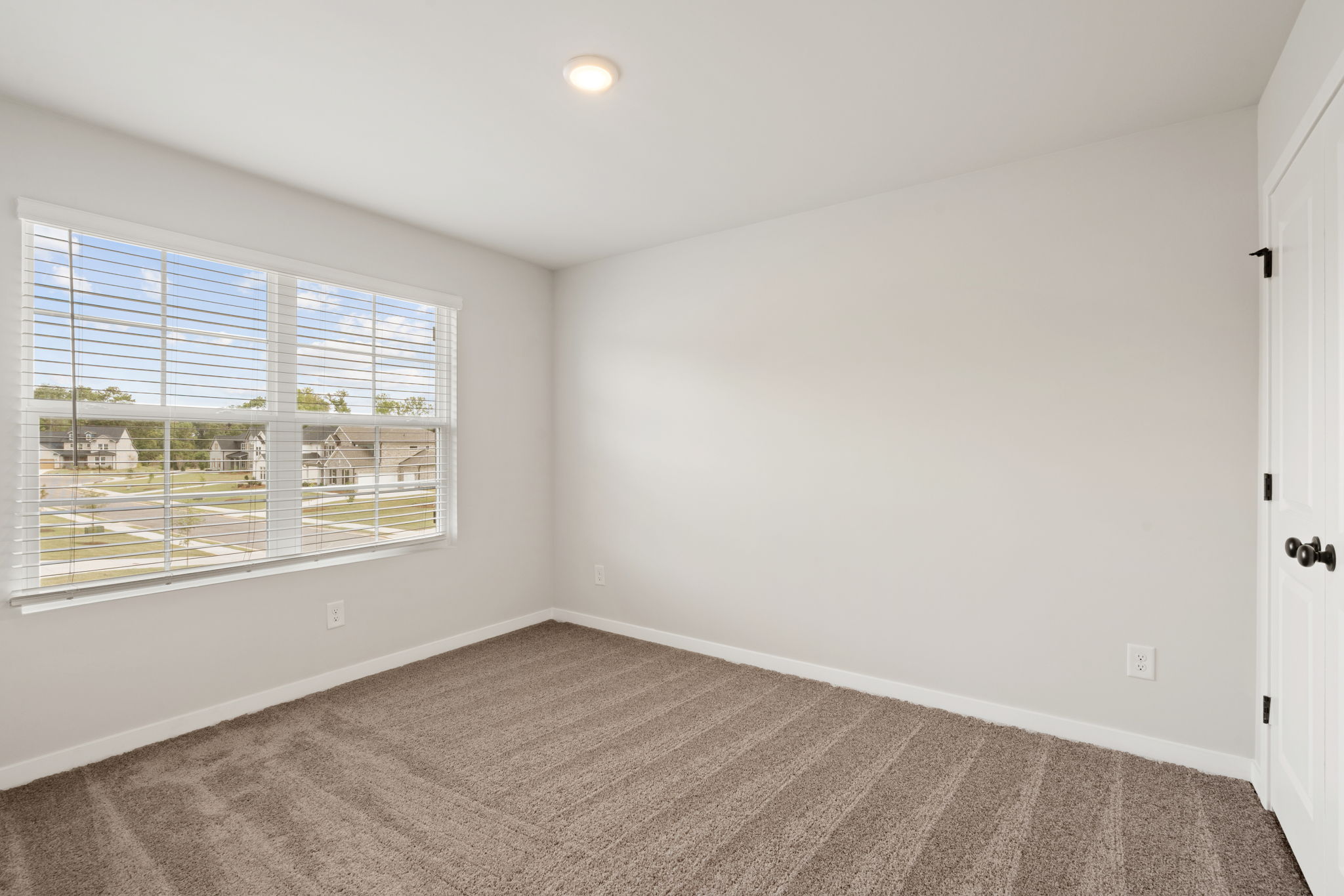 A room with a window and a carpet.