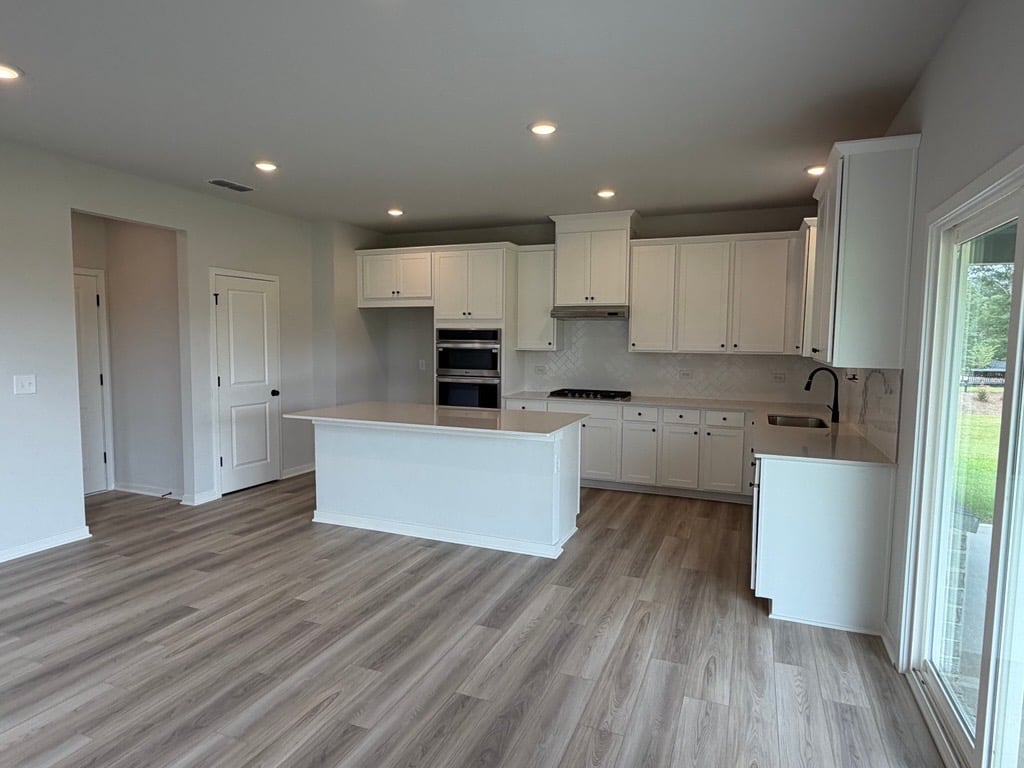 A kitchen with white cabinets.