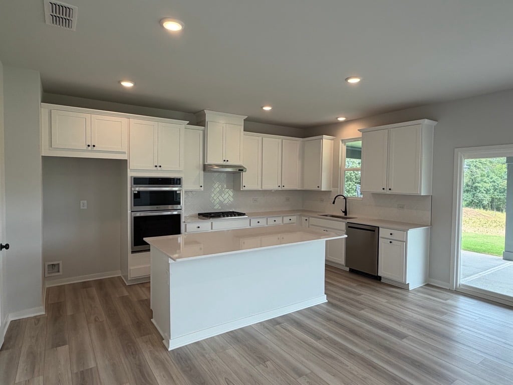 A kitchen with white cabinets.