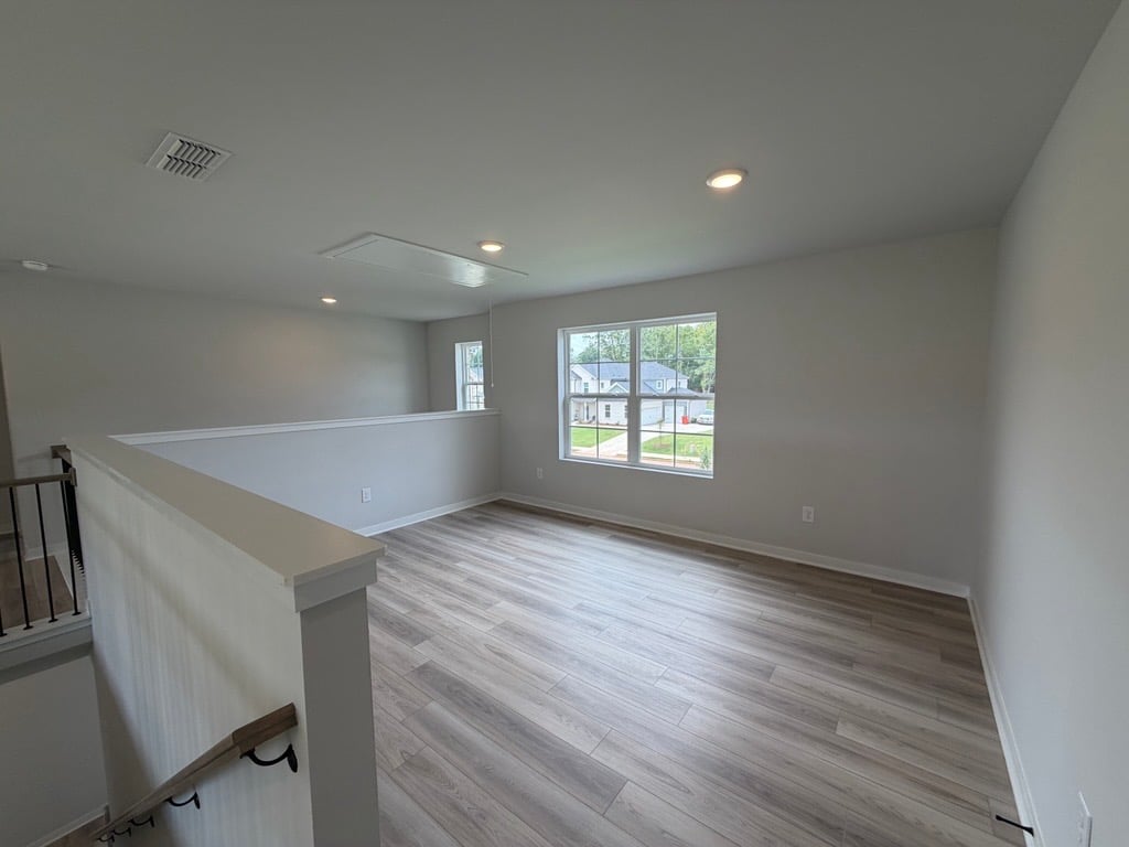A room with a wood floor and a window.