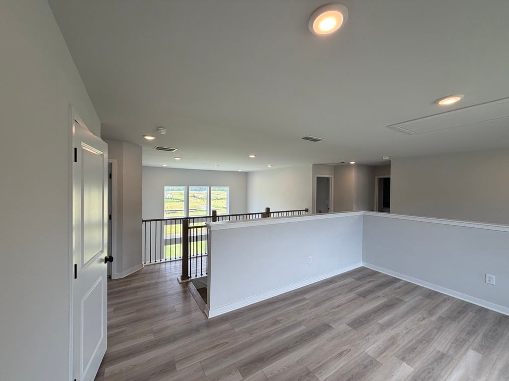 A room with a wood floor and white walls.