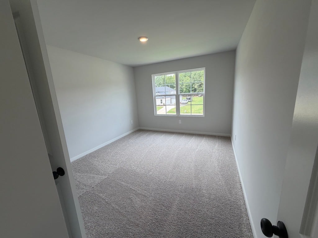 A room with a window and carpet.