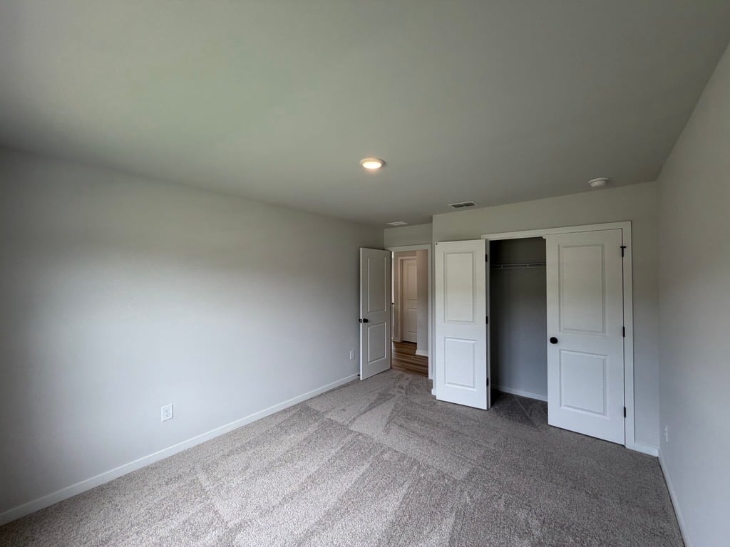 A room with white walls and a carpeted floor.